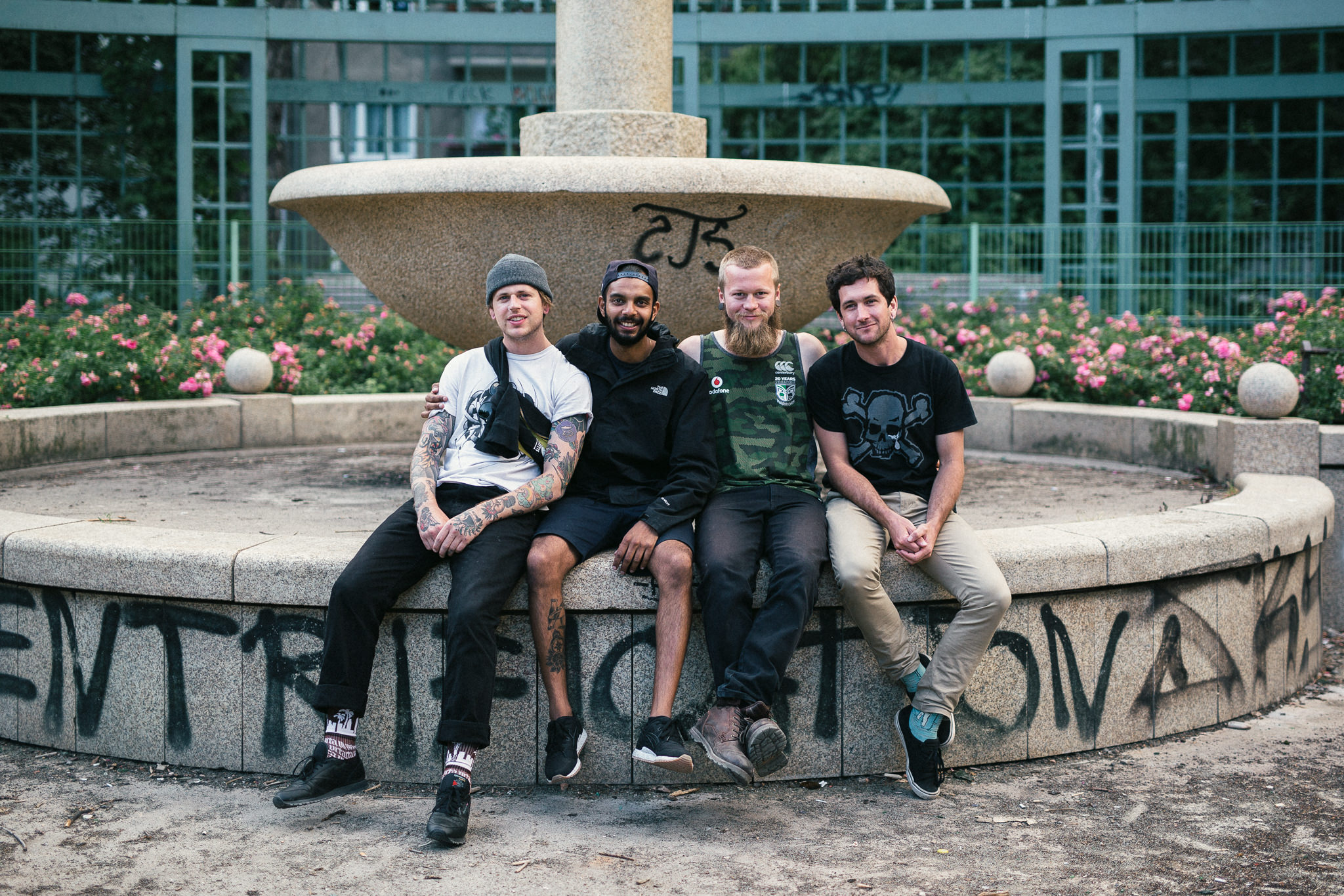 four male friends sitting on fountain