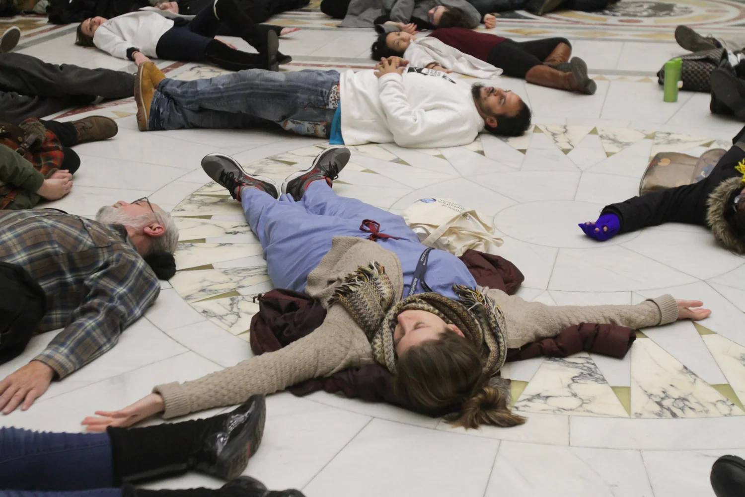 Katrina Ciraldo-Maryniuk, a family medicine intern at Boston Medical Center, lies on the ground in the Massachusetts State House in protest of Governor Baker's recent budget cuts to substance abuse prevention programs. "My best friend died from an overdose in my first year of med school," she said.