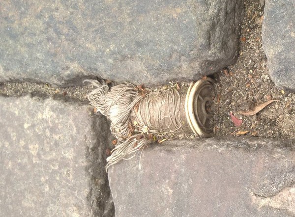 Thread is everywhere ! (spool found in Berlin's cobblestone pavement...)