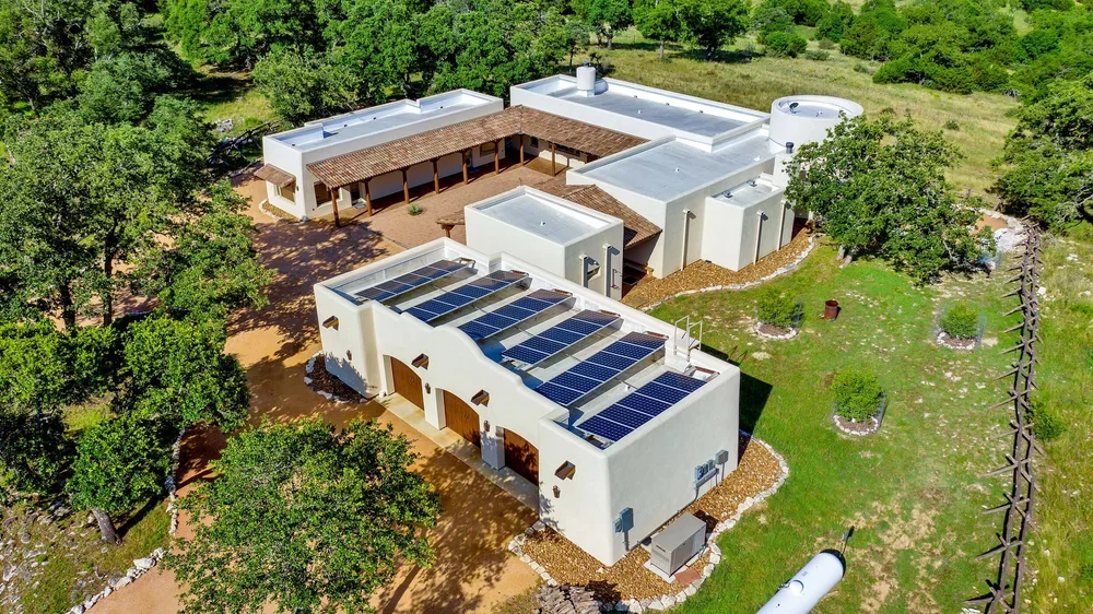  A large residential home featuring solar panels installed on the roof, showcasing sustainable energy use.