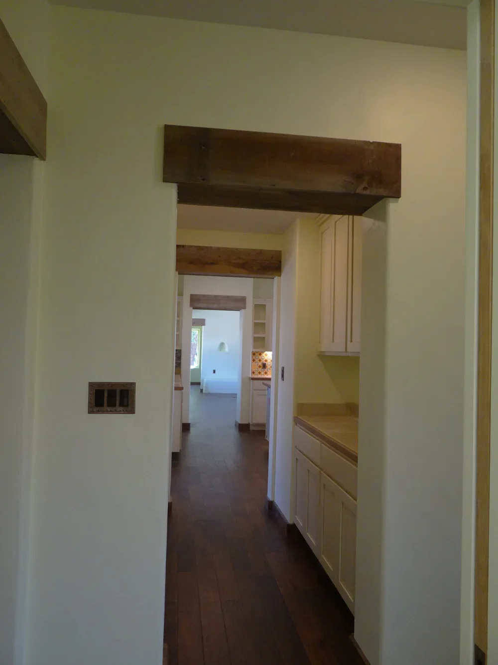 A hallway featuring a wooden beam overhead, enhancing the architectural design of the space.