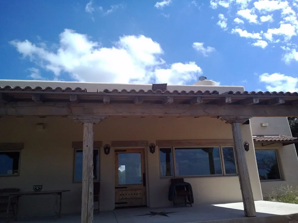 A house featuring a covered patio and a wooden roof, showcasing a blend of outdoor and architectural design.

