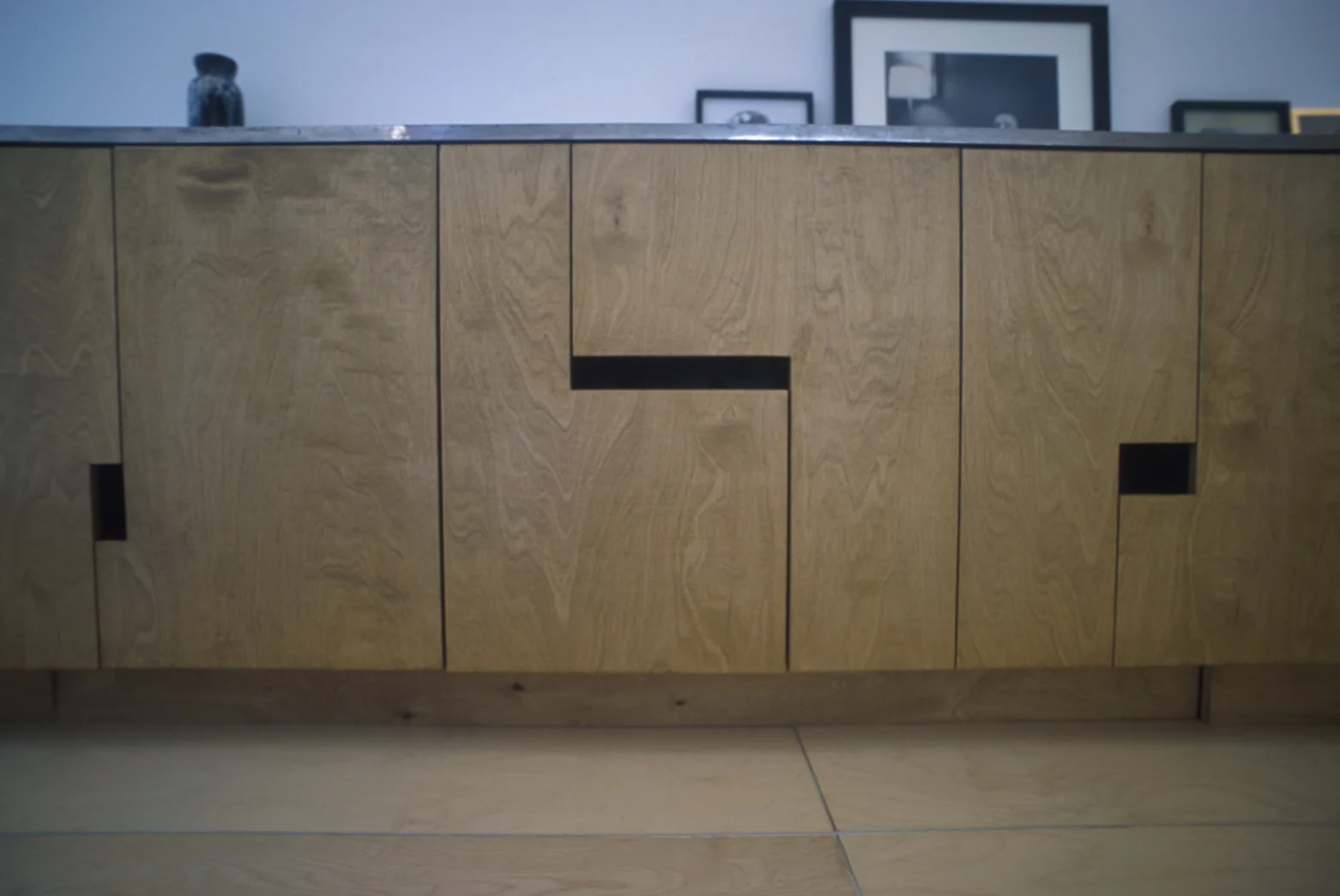   This installation was carried out without the use of cabinet hardware such as pulls or handles, instead using harmonious geometries to create cutaways which would fulfill those functions.  