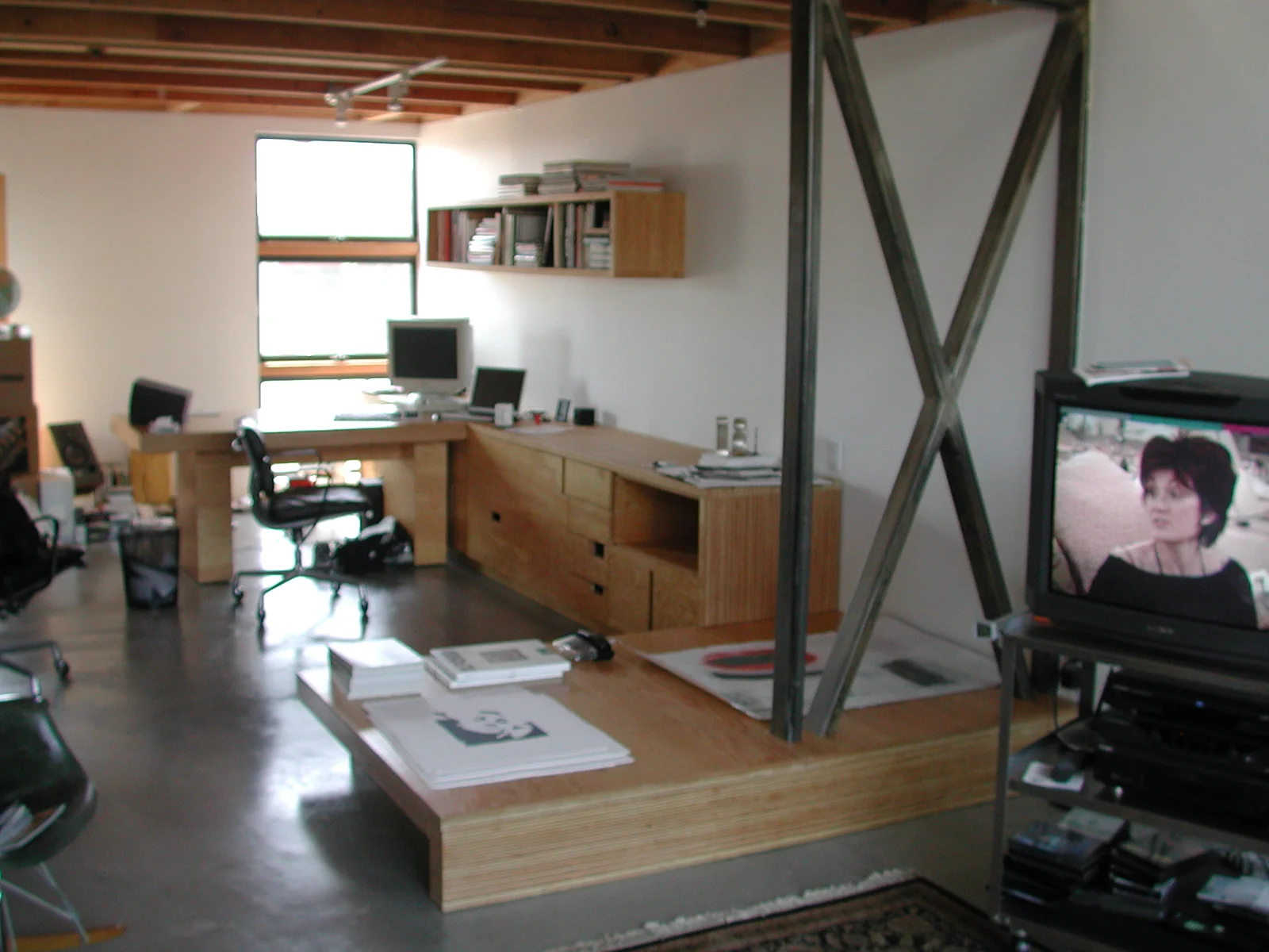  This is an-office installation designed for record executive who works primarily in the production of album art. The installation is comprised of cabinetry, a mobile desk that docks in it, a bookshelf, and a daybed that bridges the living area and t