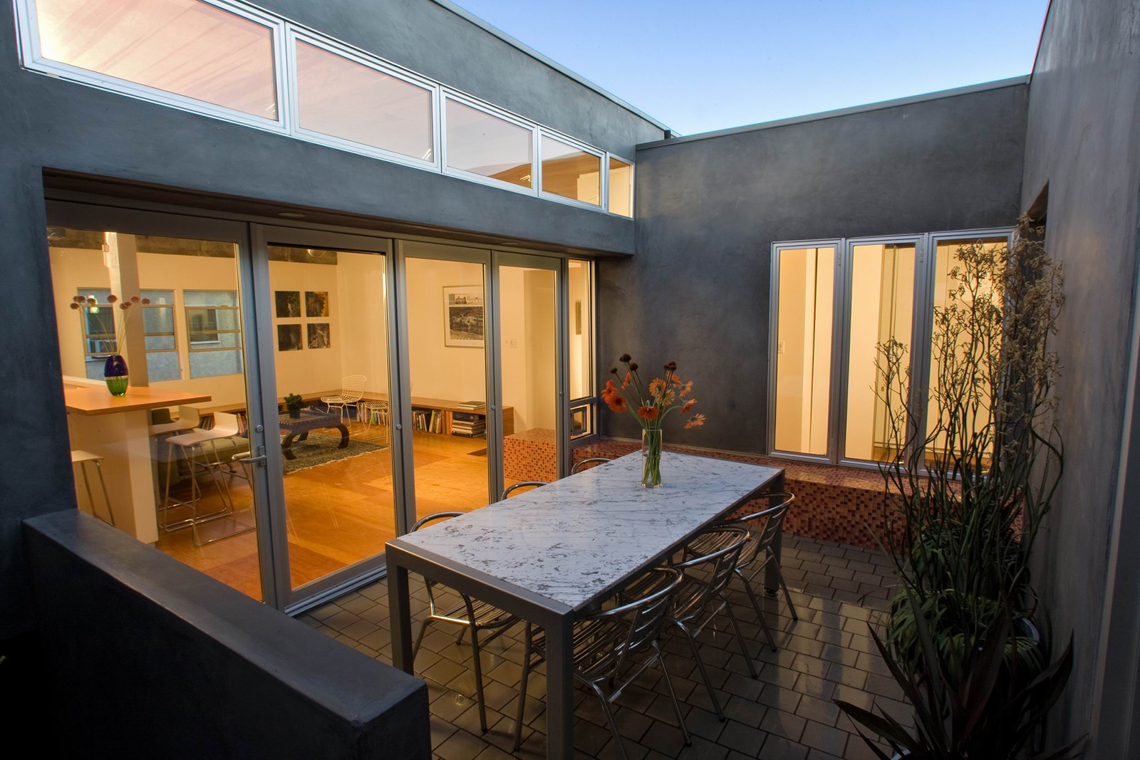 The project addresses the need for outdoor living space in a dense urban environment through the introduction of a courtyard which serves as an entry court and formal dining room.