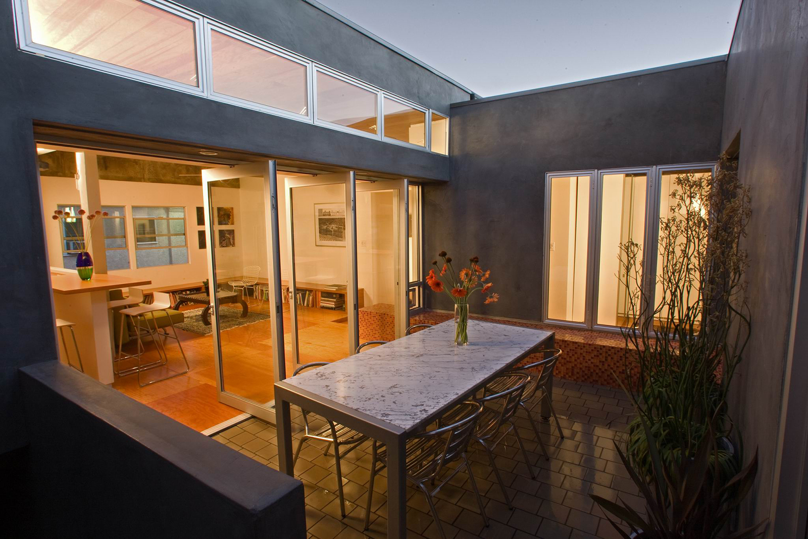 The glass doors where the living room meets the courtyard open in their entirety to both cool the apartment interior and provide a continuous indoor-outdoor experience. 