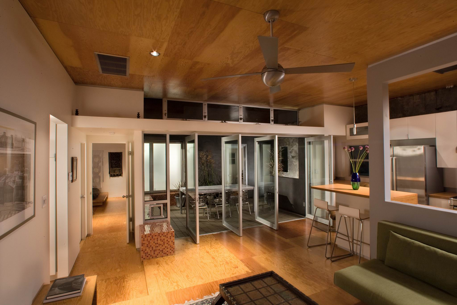 The living room doors can be configured to maximize the indoor-outdoor experience with the dining room, as seen here at dusk.