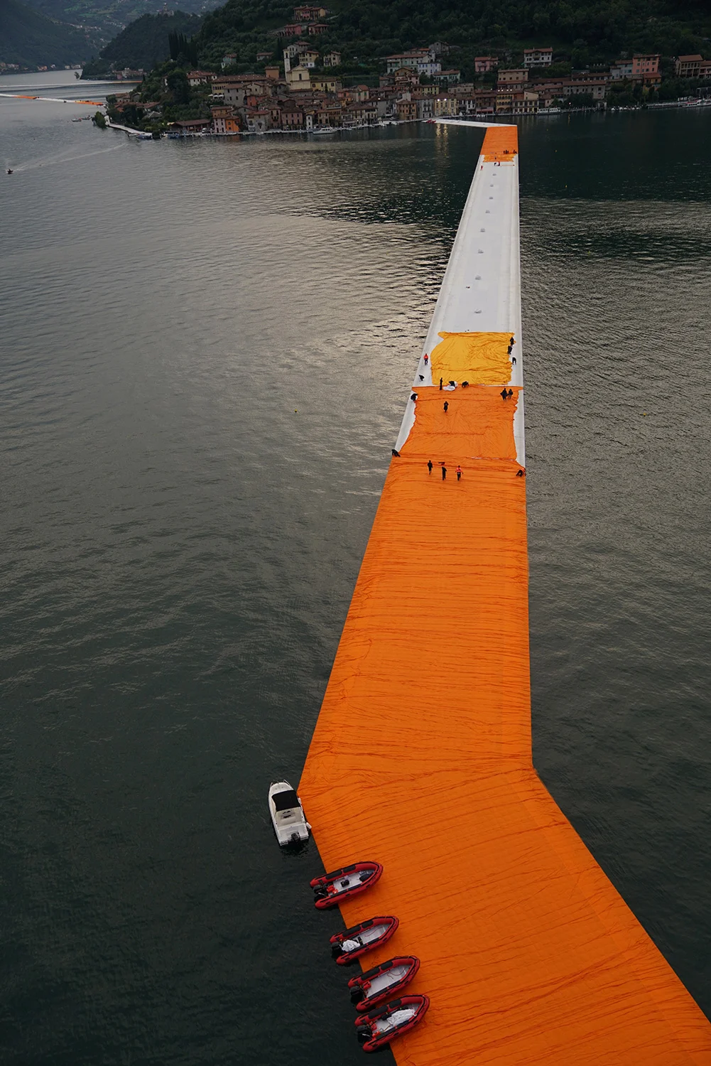 From the evening of June 15 to the evening of June 17, teams unfurl 100,000 square meters of shimmering dahlia-yellow fabric on the piers and pedestrian streets in Sulzano and Peschiera Maraglio