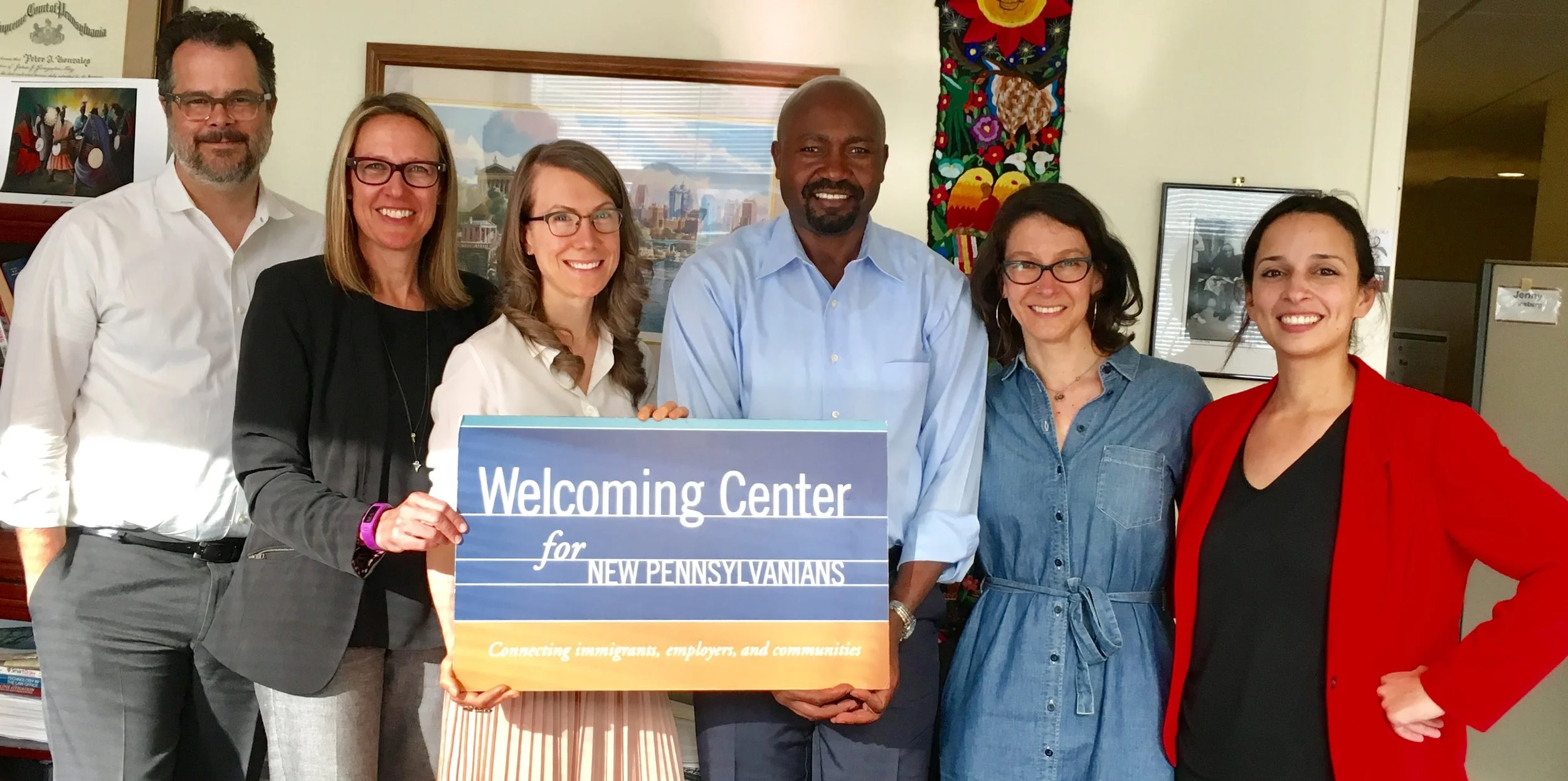 (from left to right) Peter Gonzales, President and CEO of The Welcoming Center, Rebecca Rathje, Director of Development and Communications, Nicole Pumphrey, Director of Strategic Partnerships, Herman Nyamunga, Director of Entrepreneurial Services, accept 100 Women's donation from its founder, Elizabeth Zack and 100 Women member and founder of ROAR, Yasmine Mustafa.