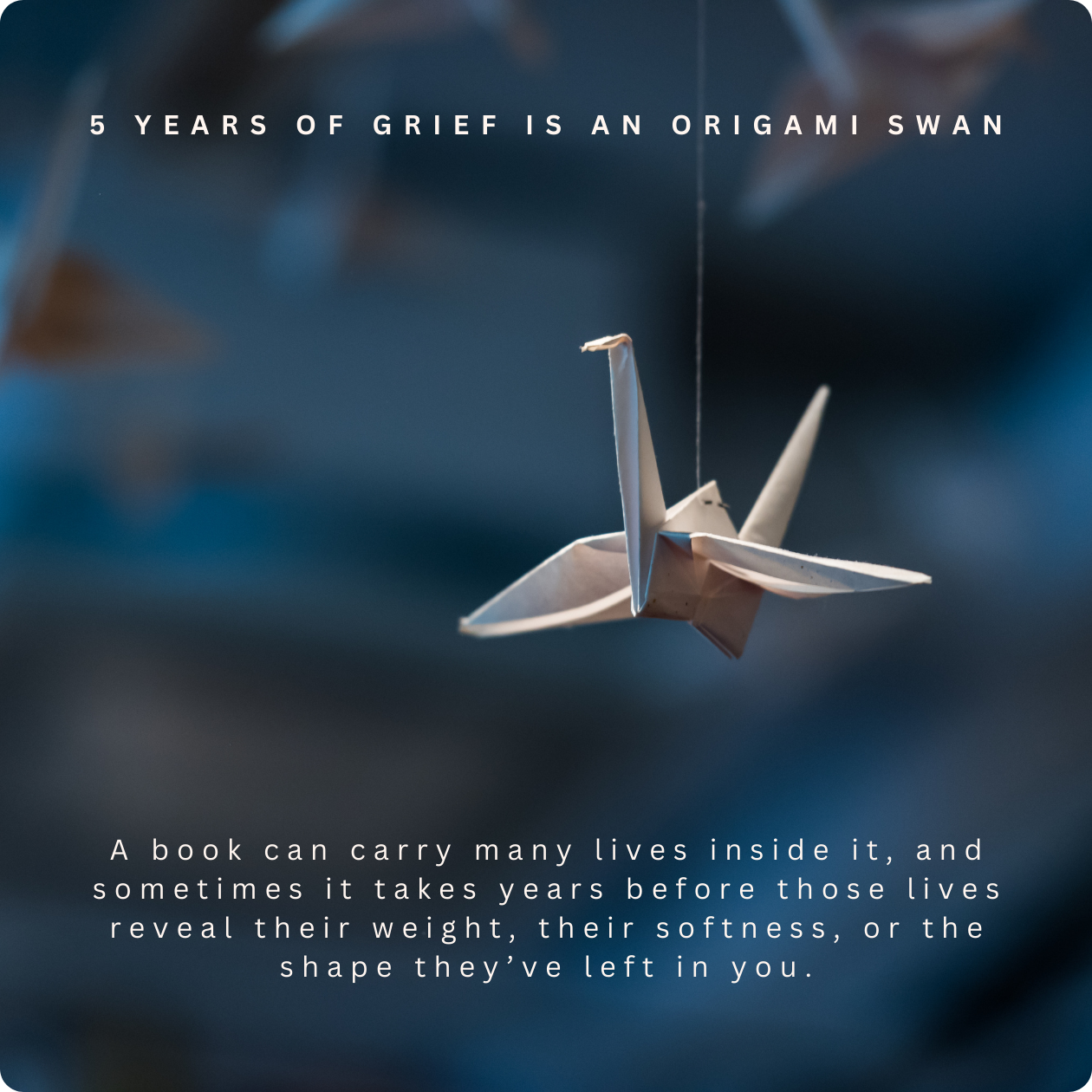Hand-folded origami swan ornament hanging on a tree, referencing the ritual practice taught in Grief Is an Origami Swan.