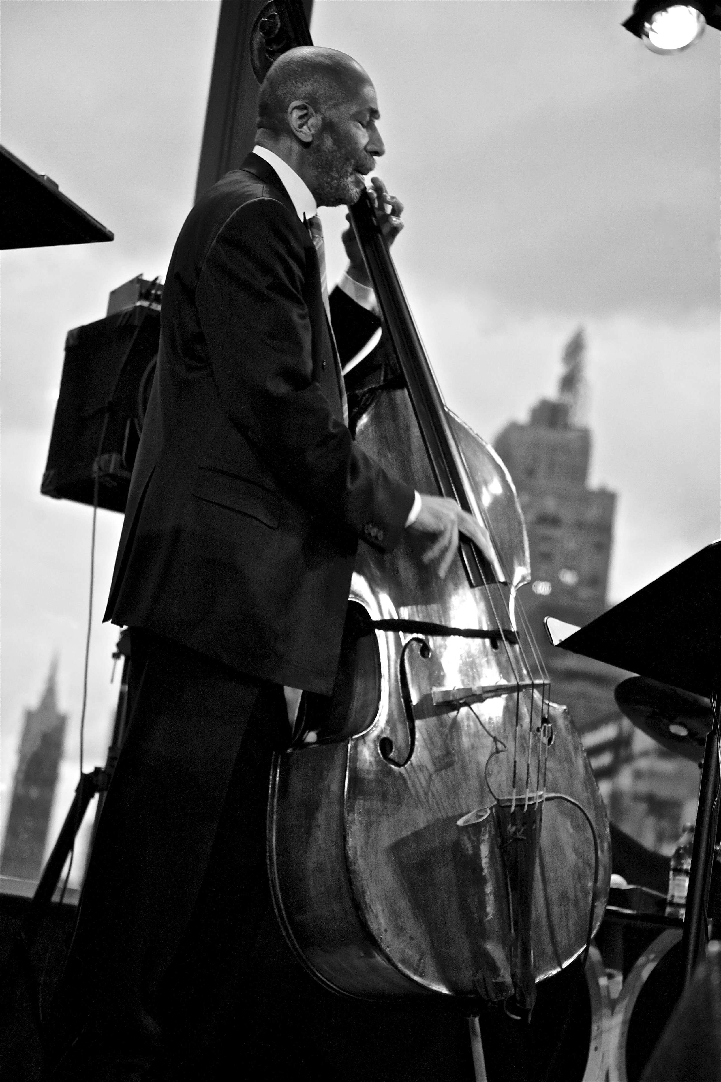 At Dizzy's Club Coca-Cola, Lincoln Center, NYC, in 2010—the year of his prestigious NEA Jazz Master nomination—this photo captures NEA Jazz Master Ron Carter. The window offered a stunning view of the NYC landscape and cloud-filled sky, making the vi