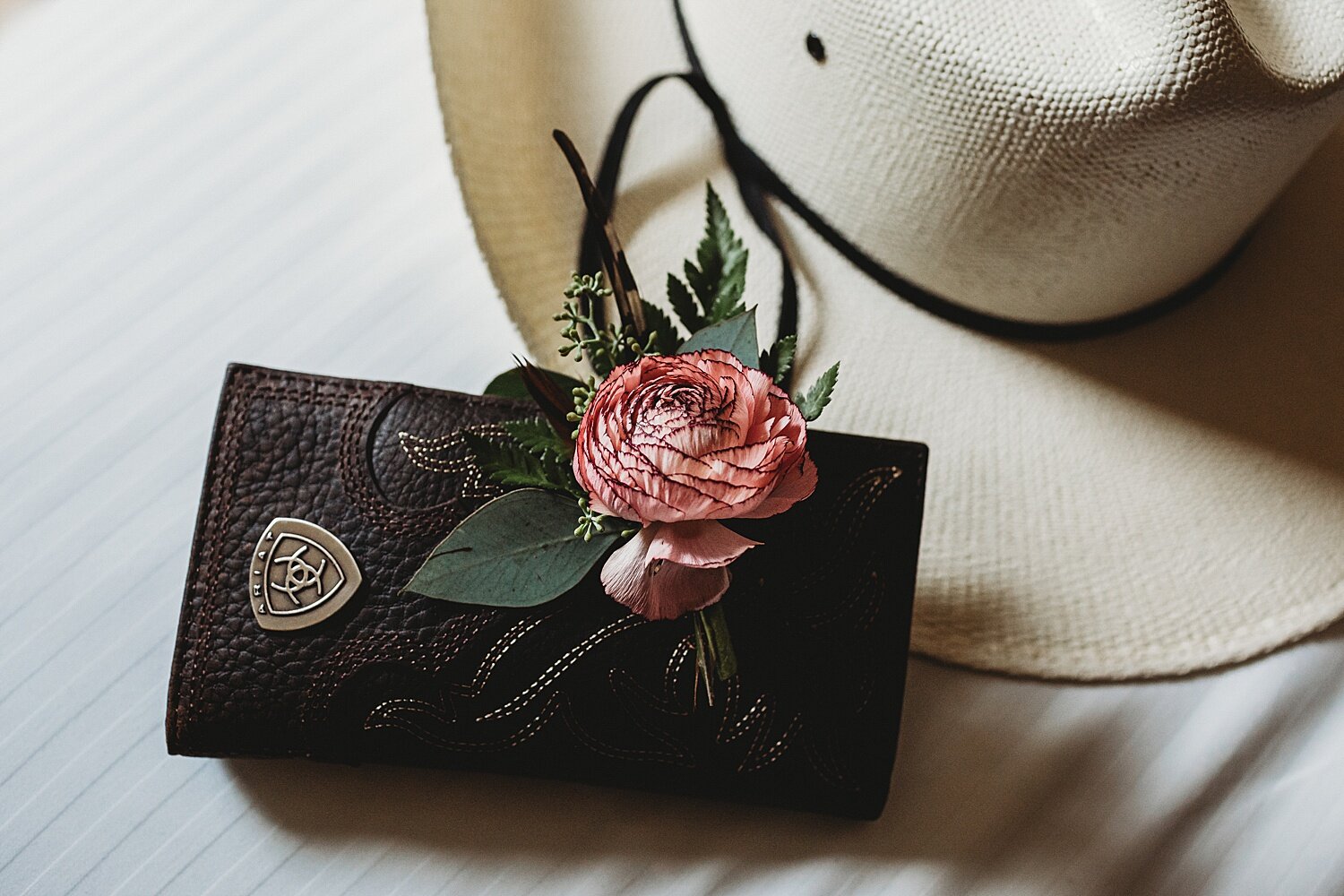 Bear Creek country themed wedding photographer cowboy hat groom details leather wallet boutonnière ranunculus