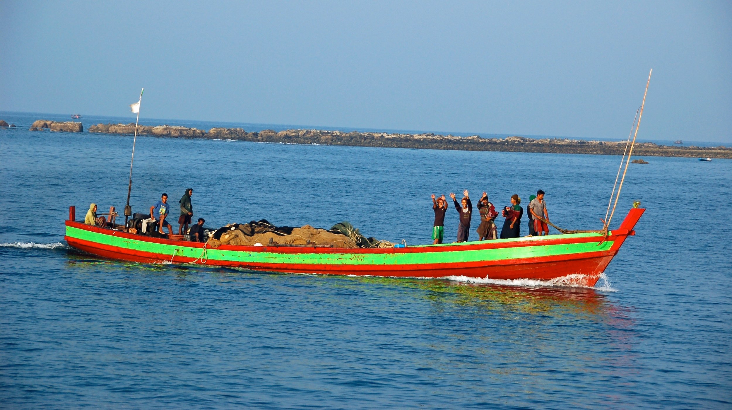 A traditional fishing boat. Notice the open deck, lack of railings, and net.