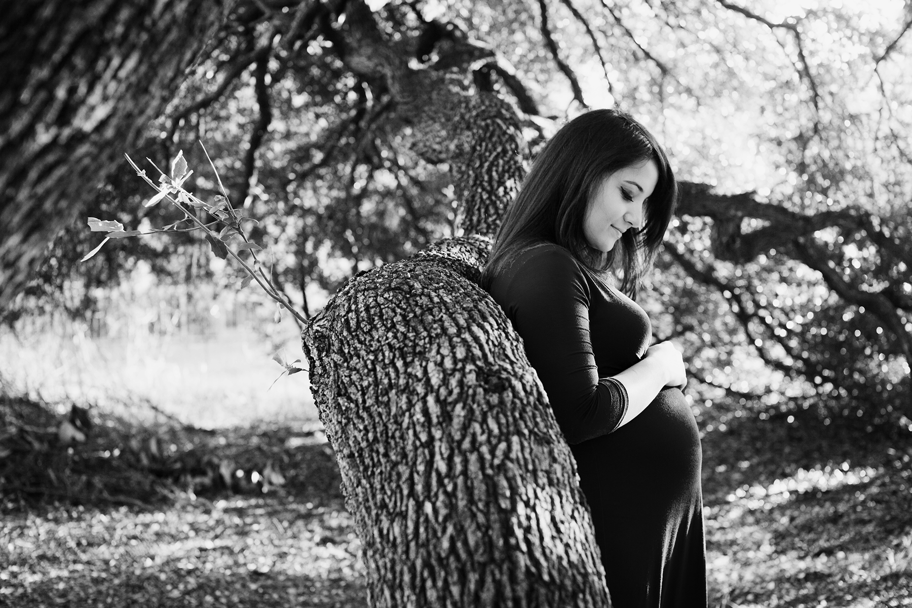 mom to be leaning on tree
