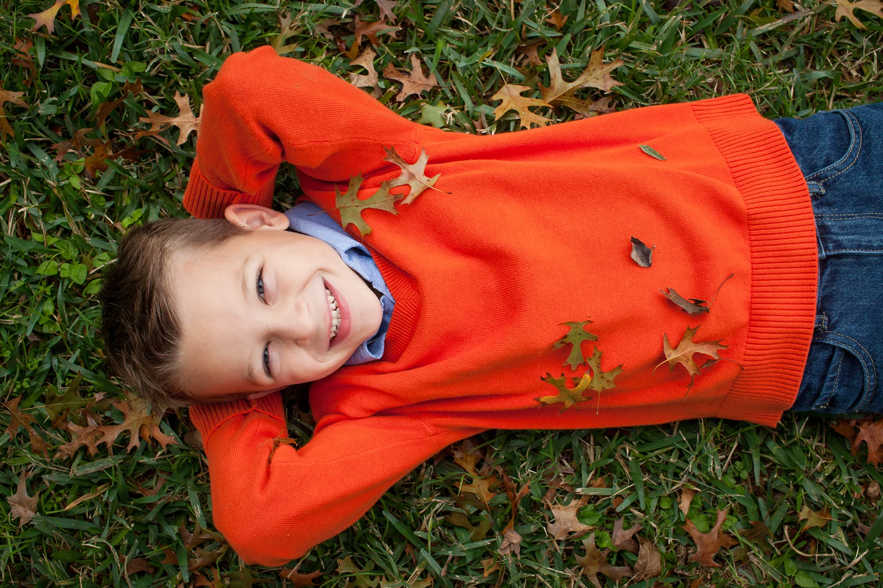 austin boy laying in leaves fall photo shoot