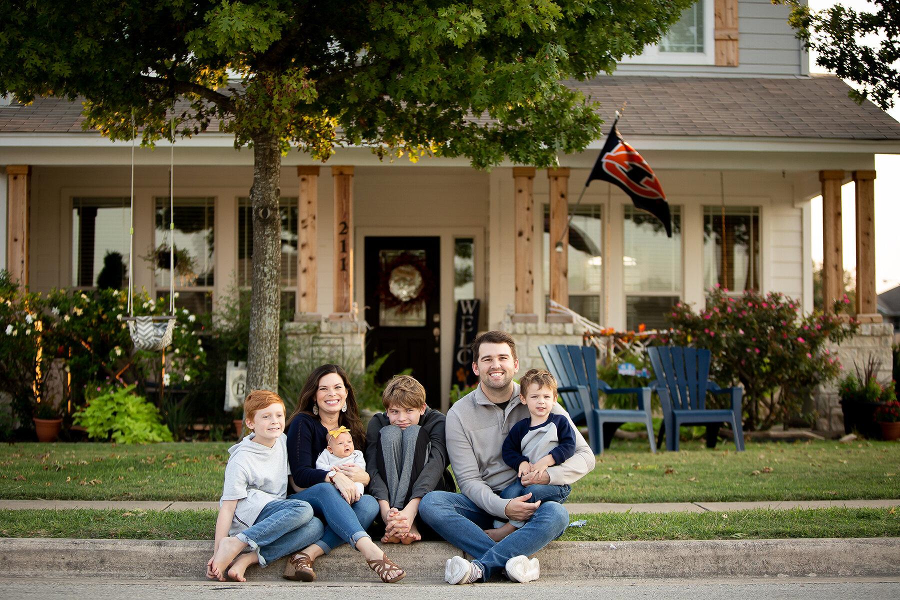 Family of 5 citting on the curb in front of their home in Austin, Tx