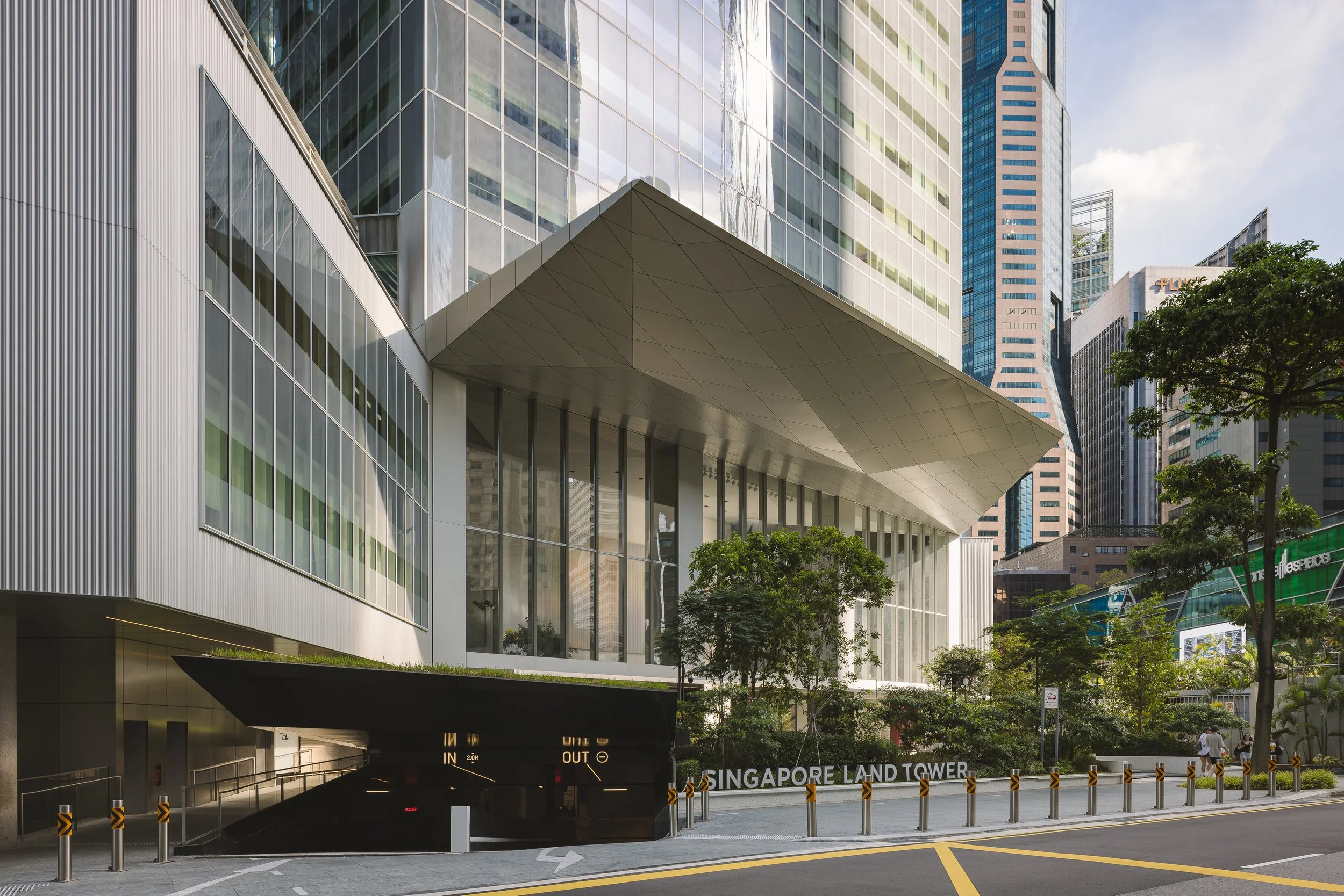 Singapore Land Tower office development in Singapore showcasing its contemporary glass façade, iconic entrance canopy and landscaped public realm. Architectural photography by Daniel Koh.