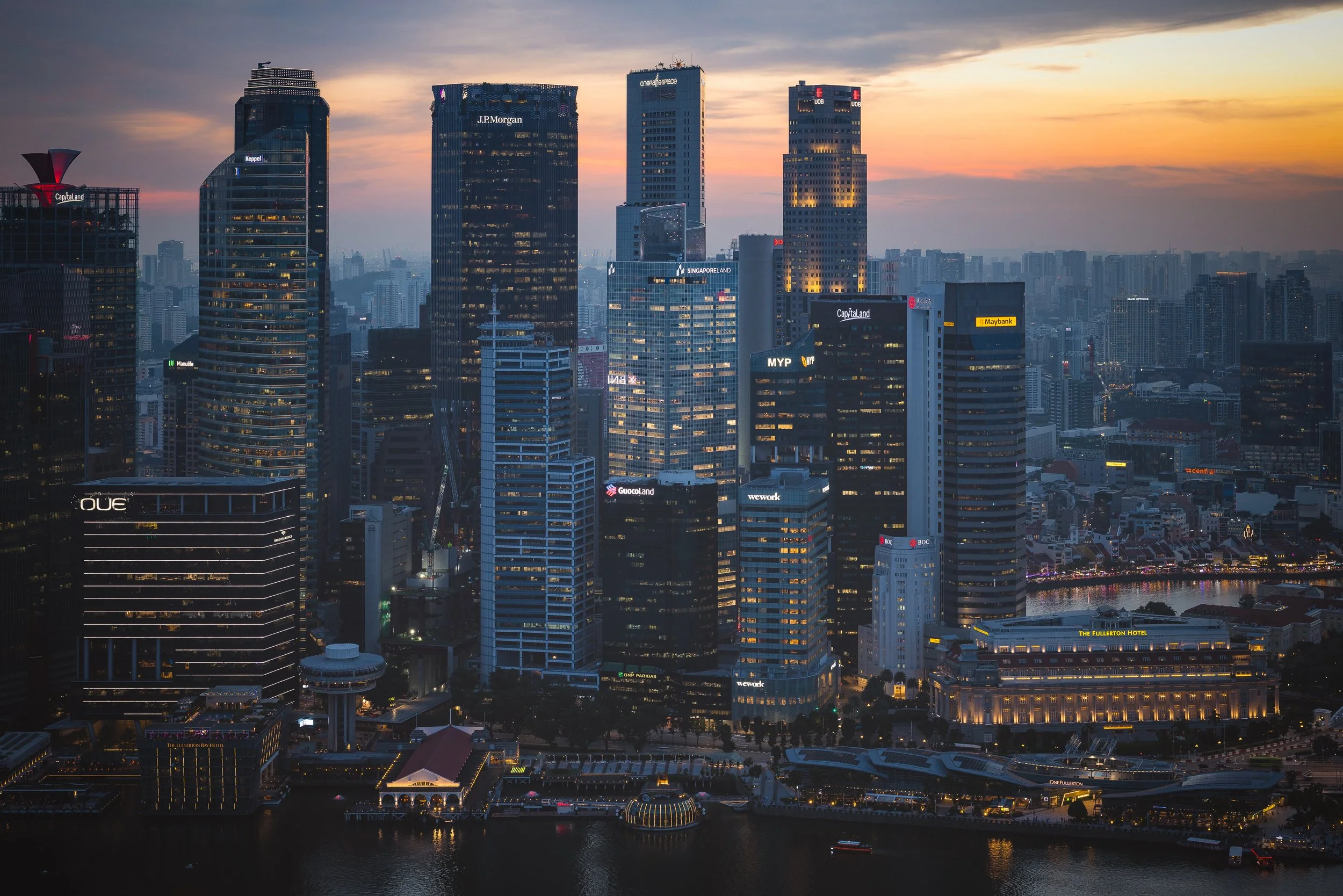 Singapore Land Tower illuminated against the Singapore skyline at dusk. Commissioned by Architects 61. Architectural photography by Daniel Koh.