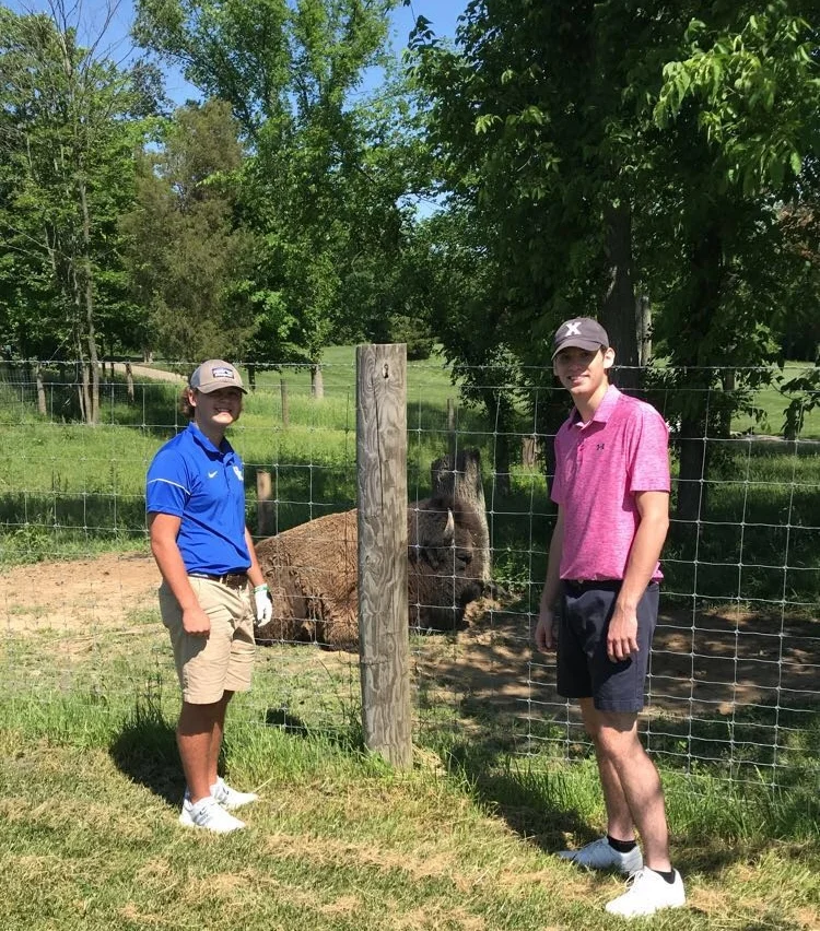 Carter Kurz and Michael Shipp pose in front of the pet buffalo on the first hole at Stonelick Hills.