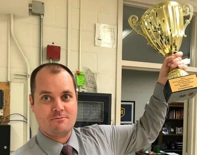 Mr. Shaffer holding the Thanksgiving Tournament trophy, photo via The Moeller Crusader