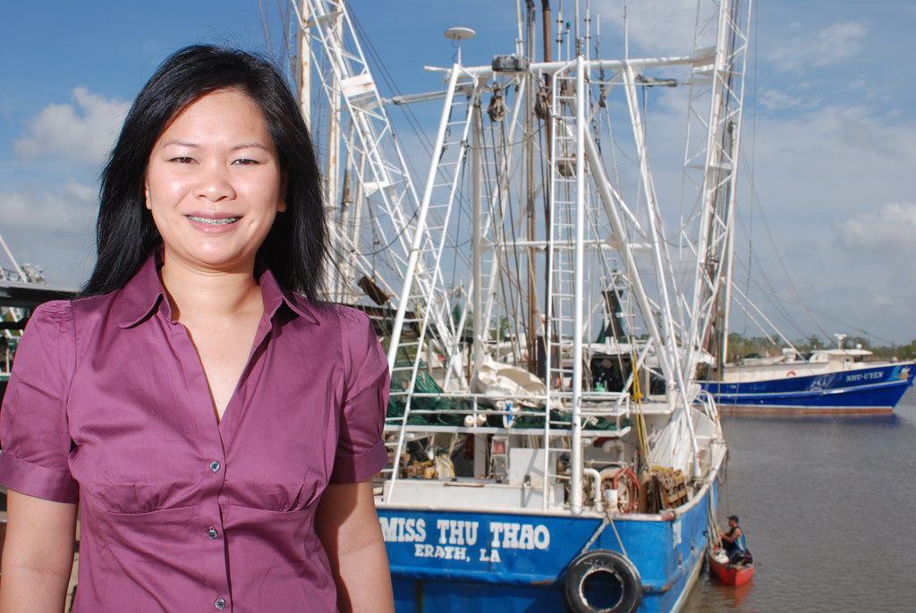 Thu Bui, a fisheries extension agent with the LSU AgCenter, in front of one of her father's shrimp boats. The boats are named after Bui and her sister. Image courtesy of the LSU AgCenter.