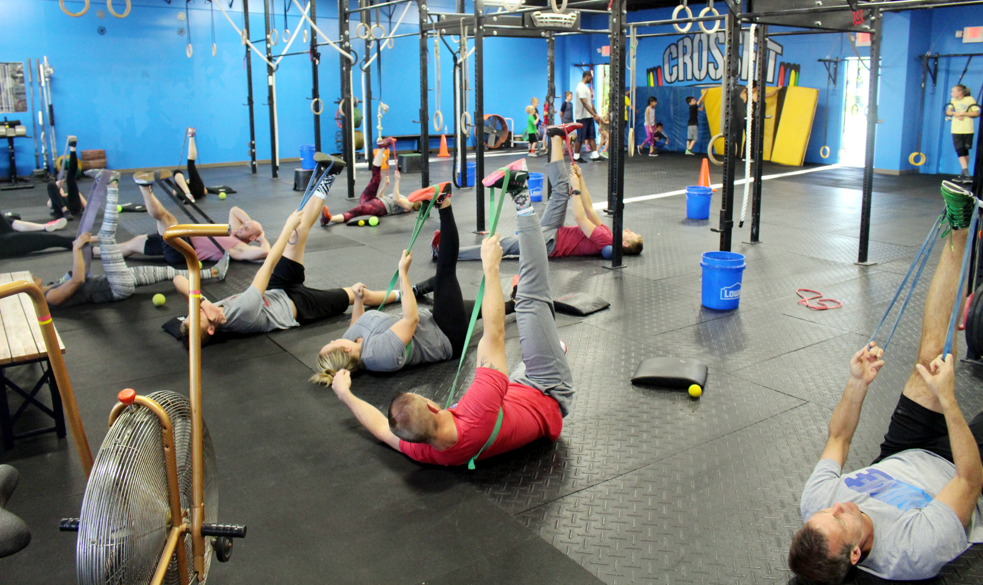 Adults stretching in the front, kids getting ready to warm-up in the back
