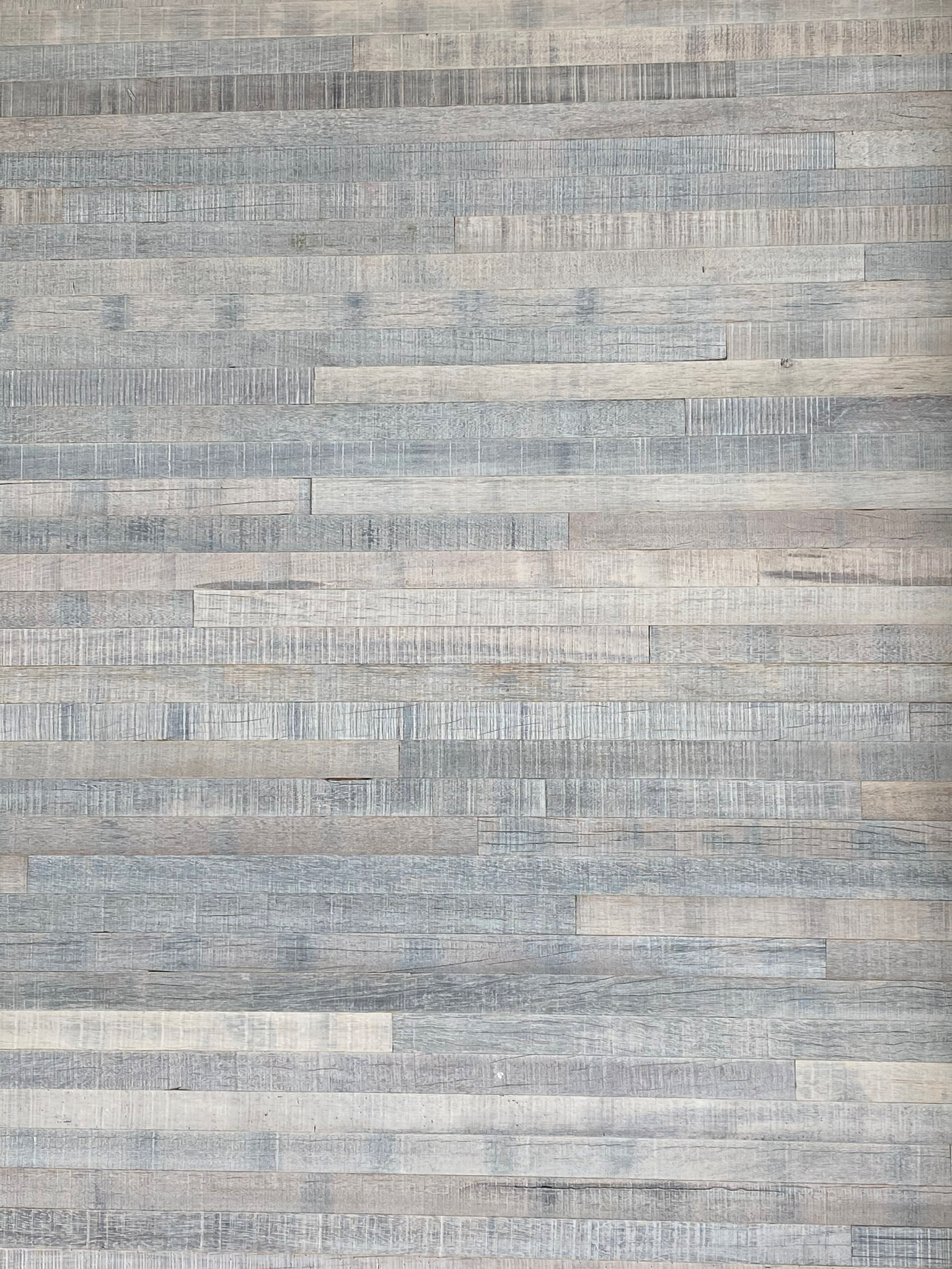 A wooden floor with horizontal planks in varying shades of gray and beige.