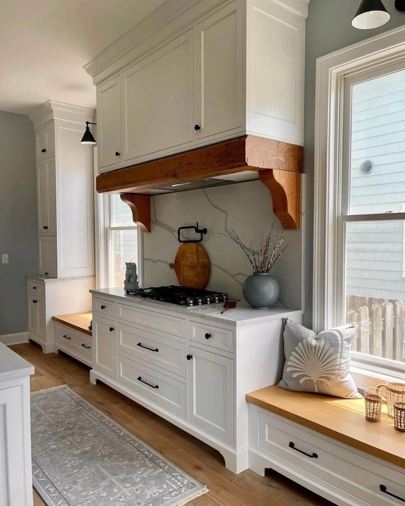 modern-kitchen-with-white-cabinetry-and-wooden-hood-above-the-stove.jpg