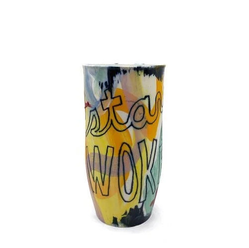Colorful ceramic cup with the text "Stay woke" written on the side.