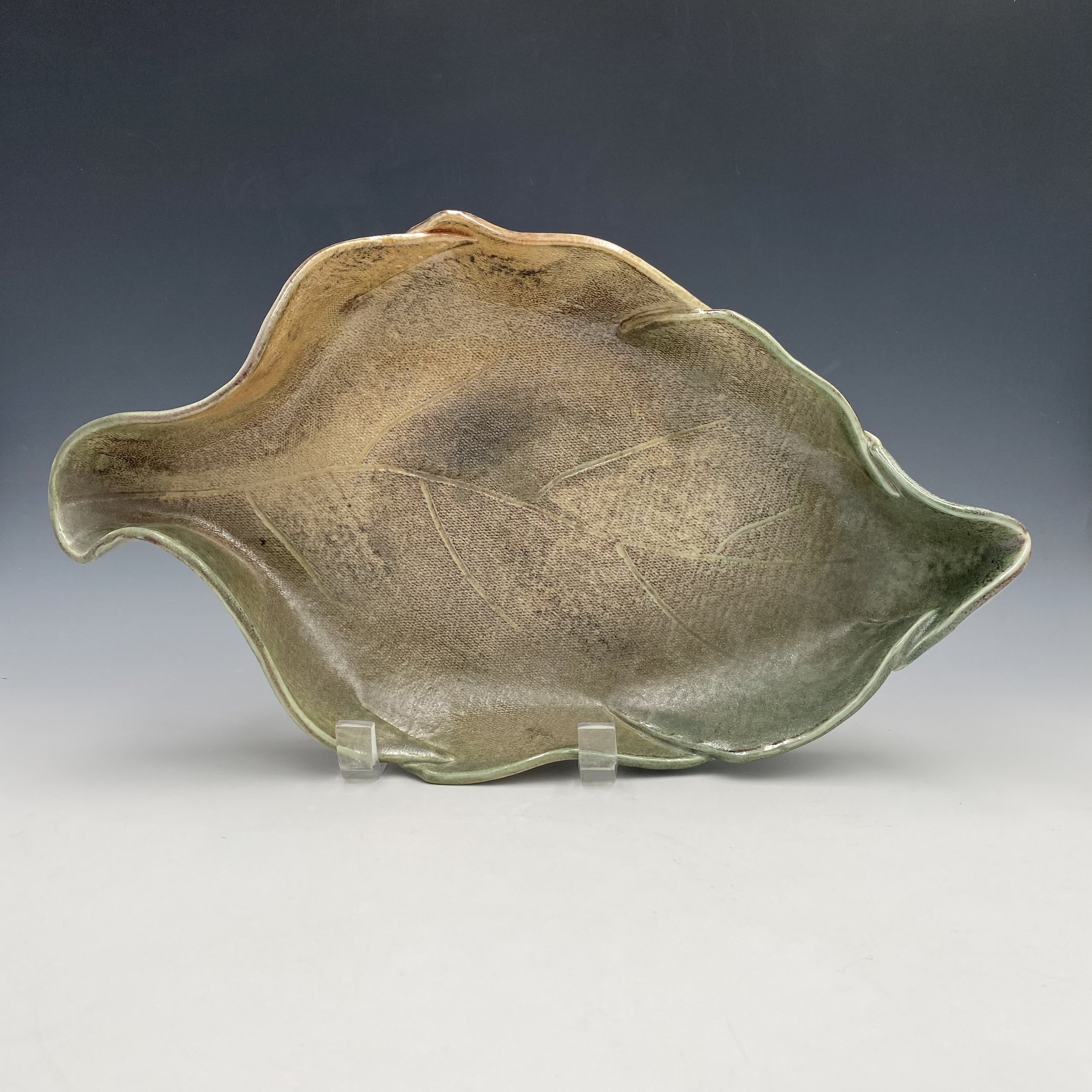 Green and earth toned ceramic leaf plate.