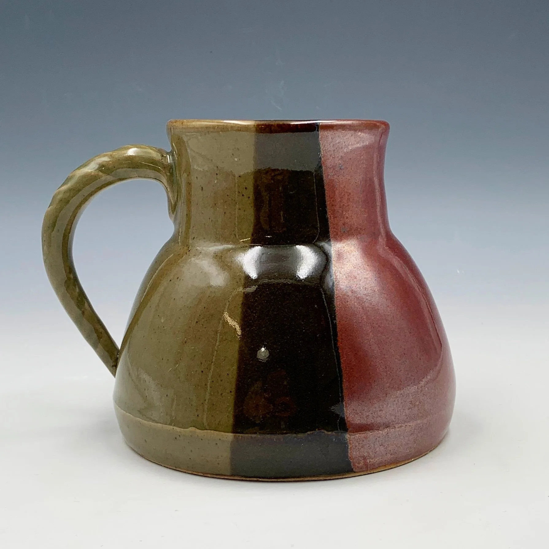 Ceramic mug with red, black and green vertical panels.