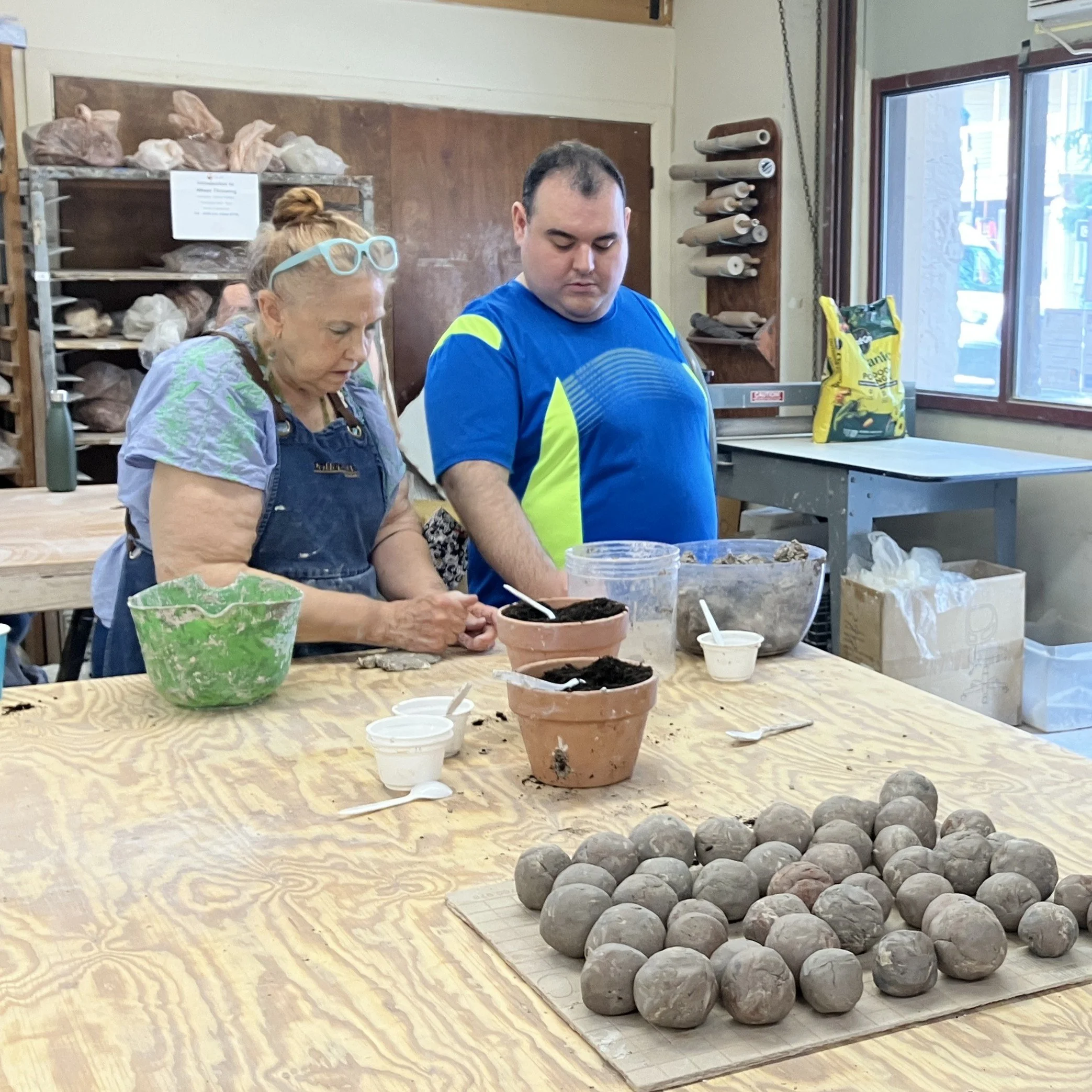 Jeanne and Richie work together to make seed bombs out of clay, soil, and seeds