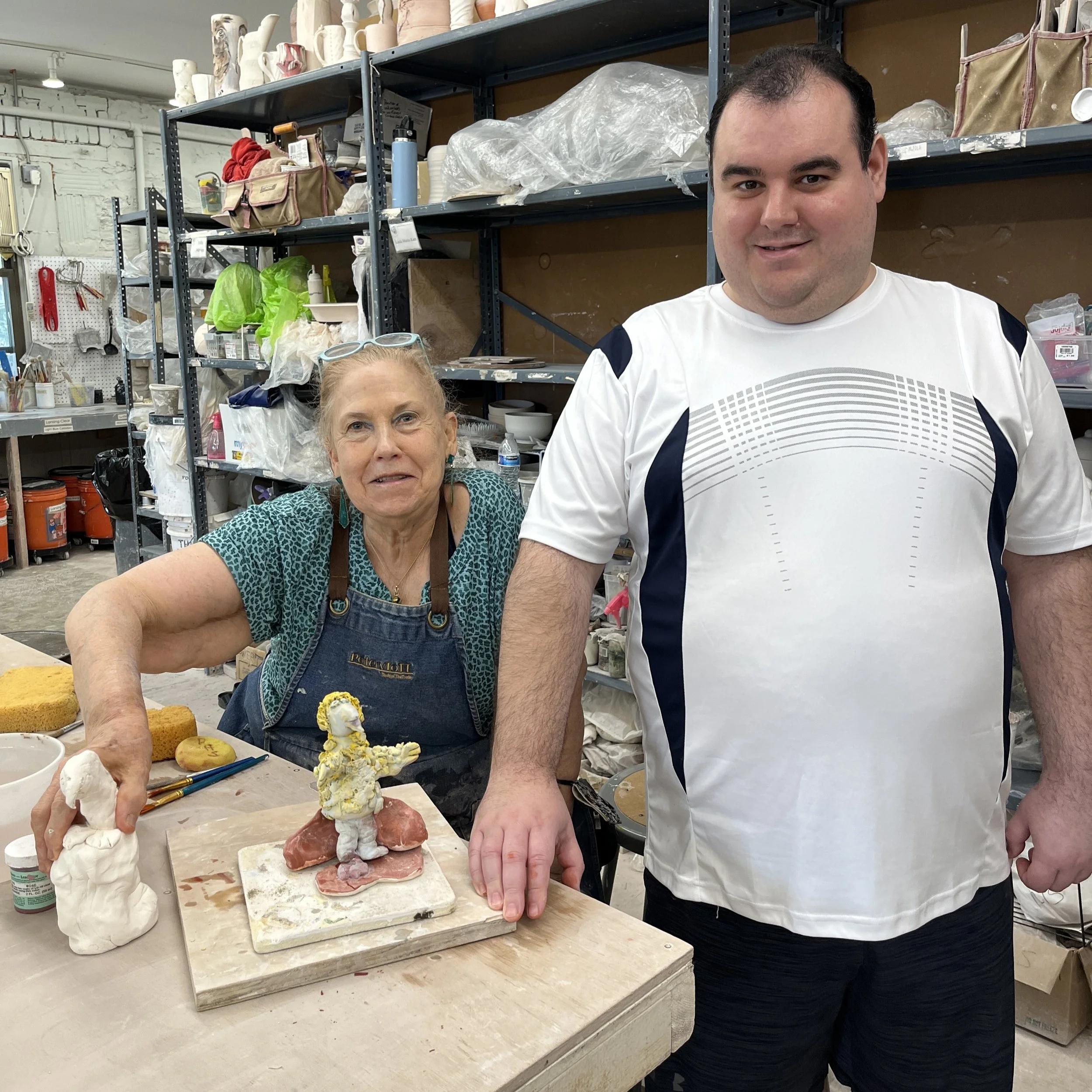 Jeanne and Richie stand next to Richie's sculpture in progress