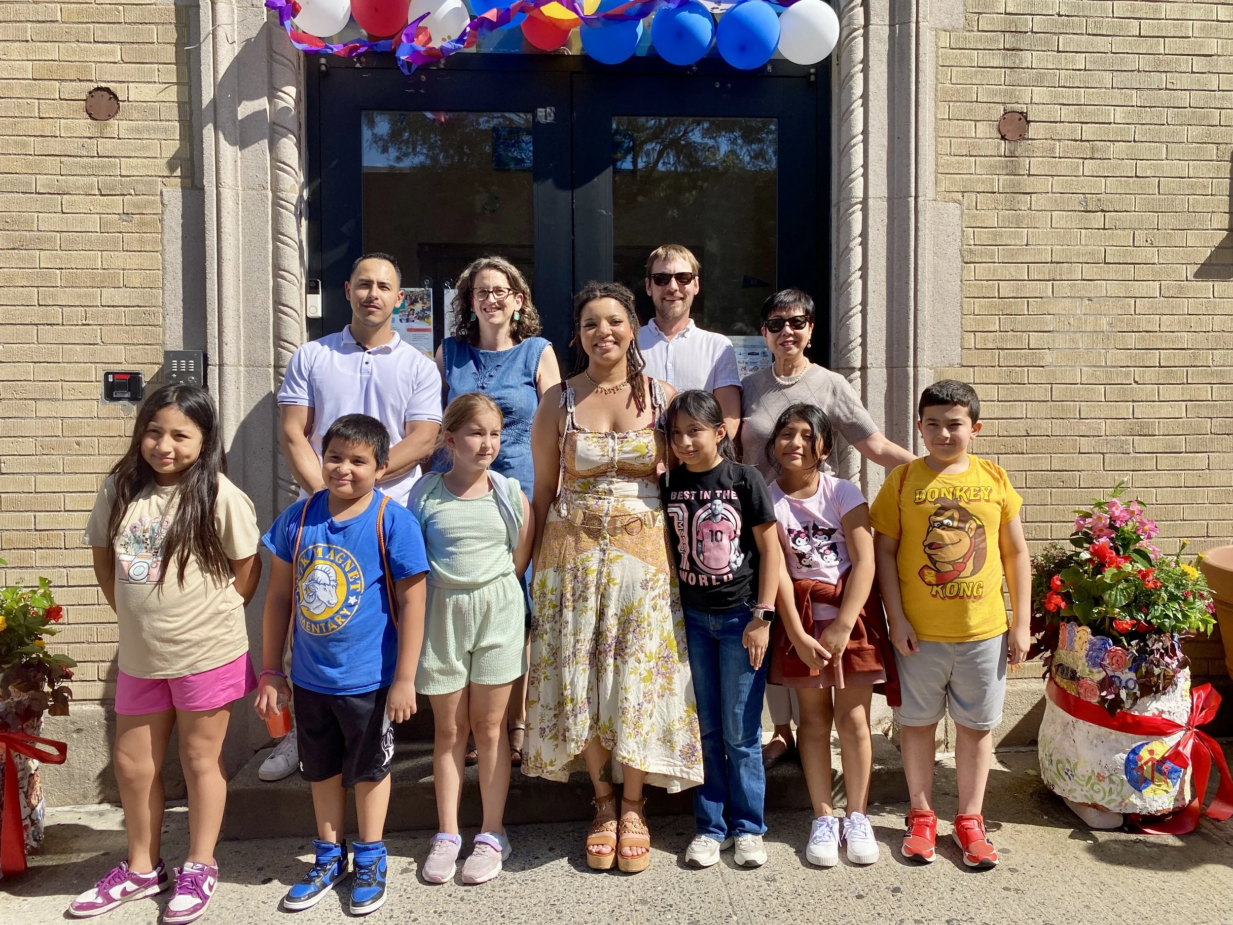 Evelyn stands with her students in front of Don Bosco
