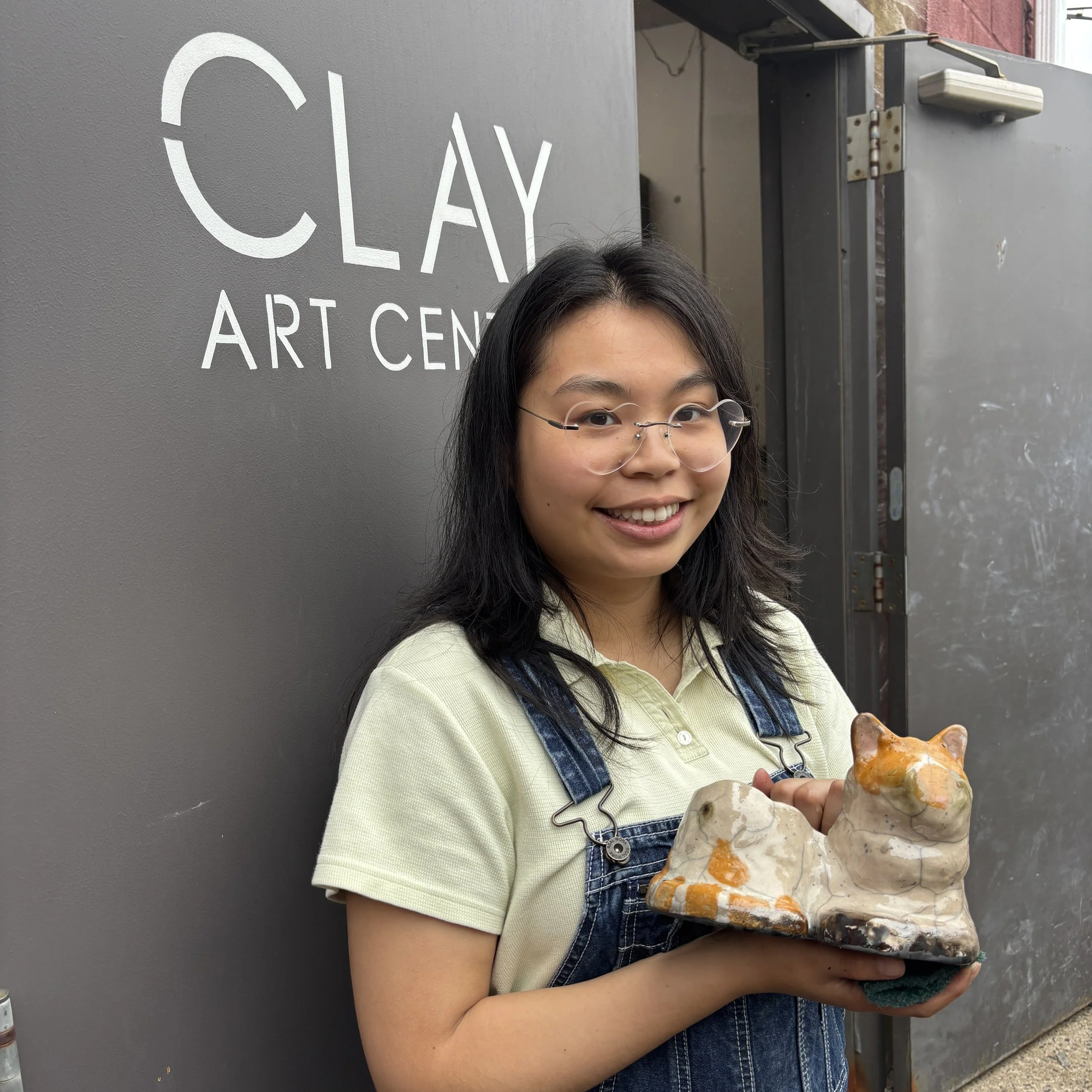 Jessica holds her cat sculpture