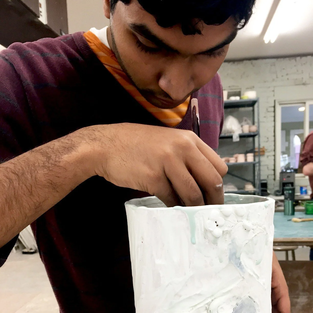 Surya smooths out the coils on his large vase