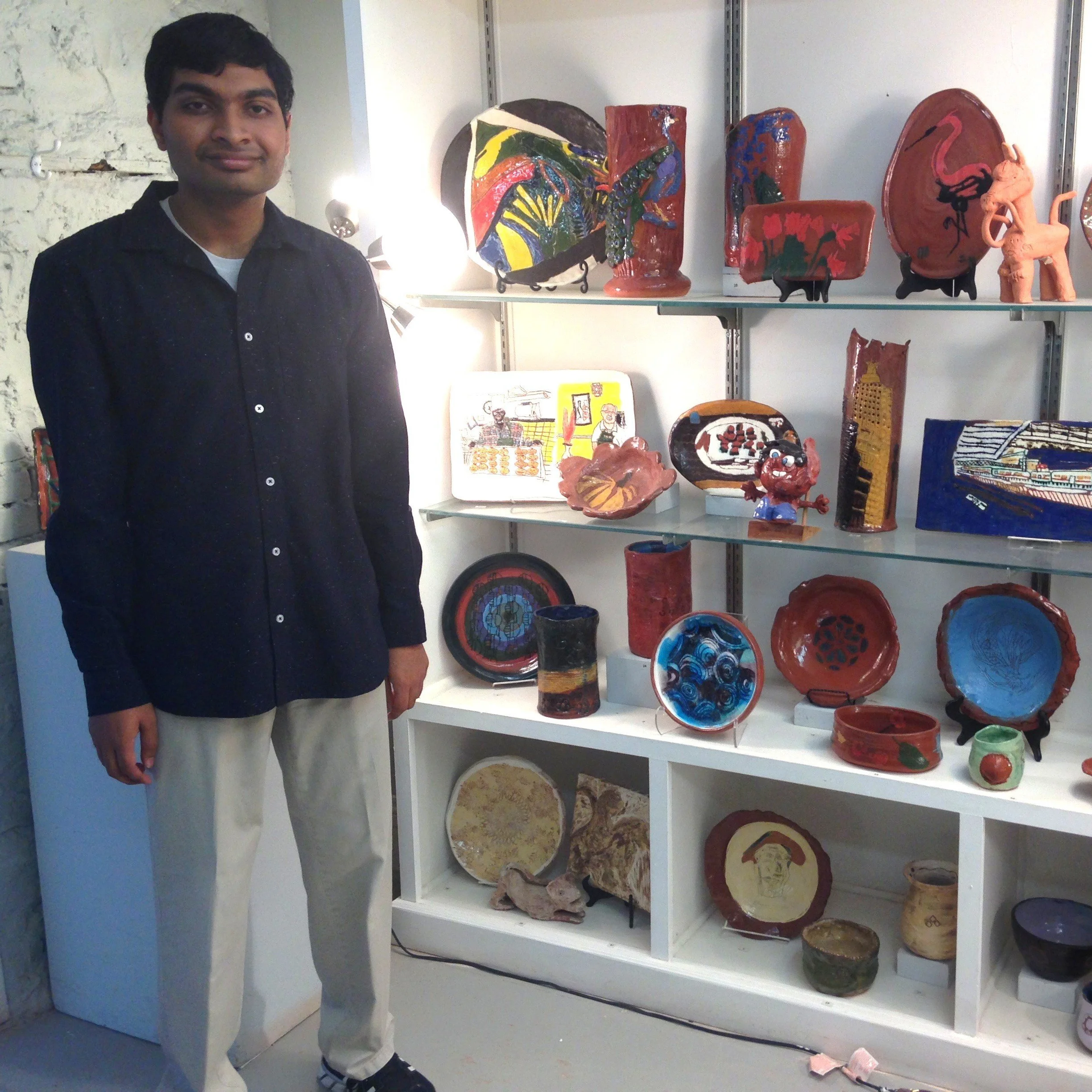 Surya stands next to the exhibition of his work in the Main Classroom