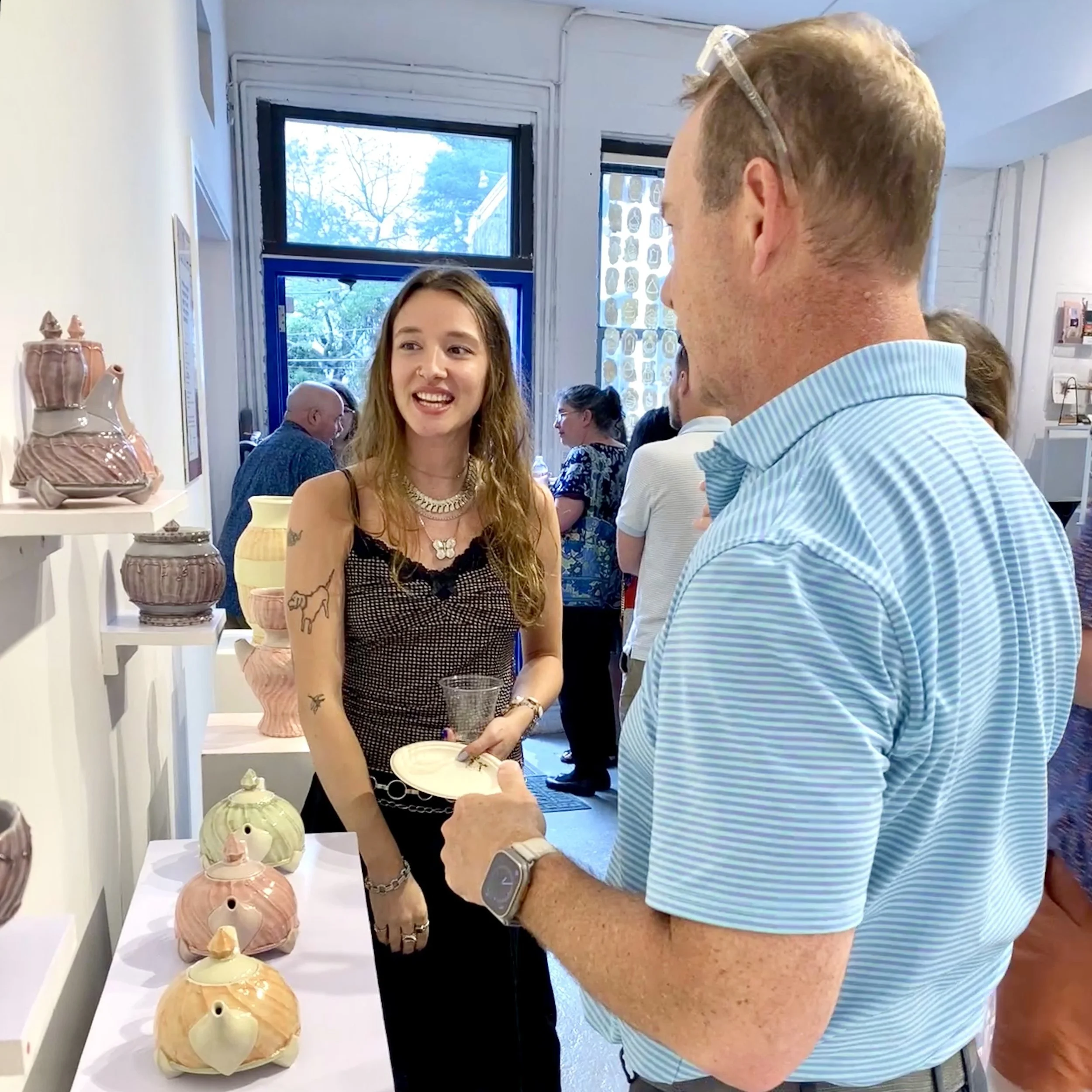 Carley speaks to a gallery visitor about her work