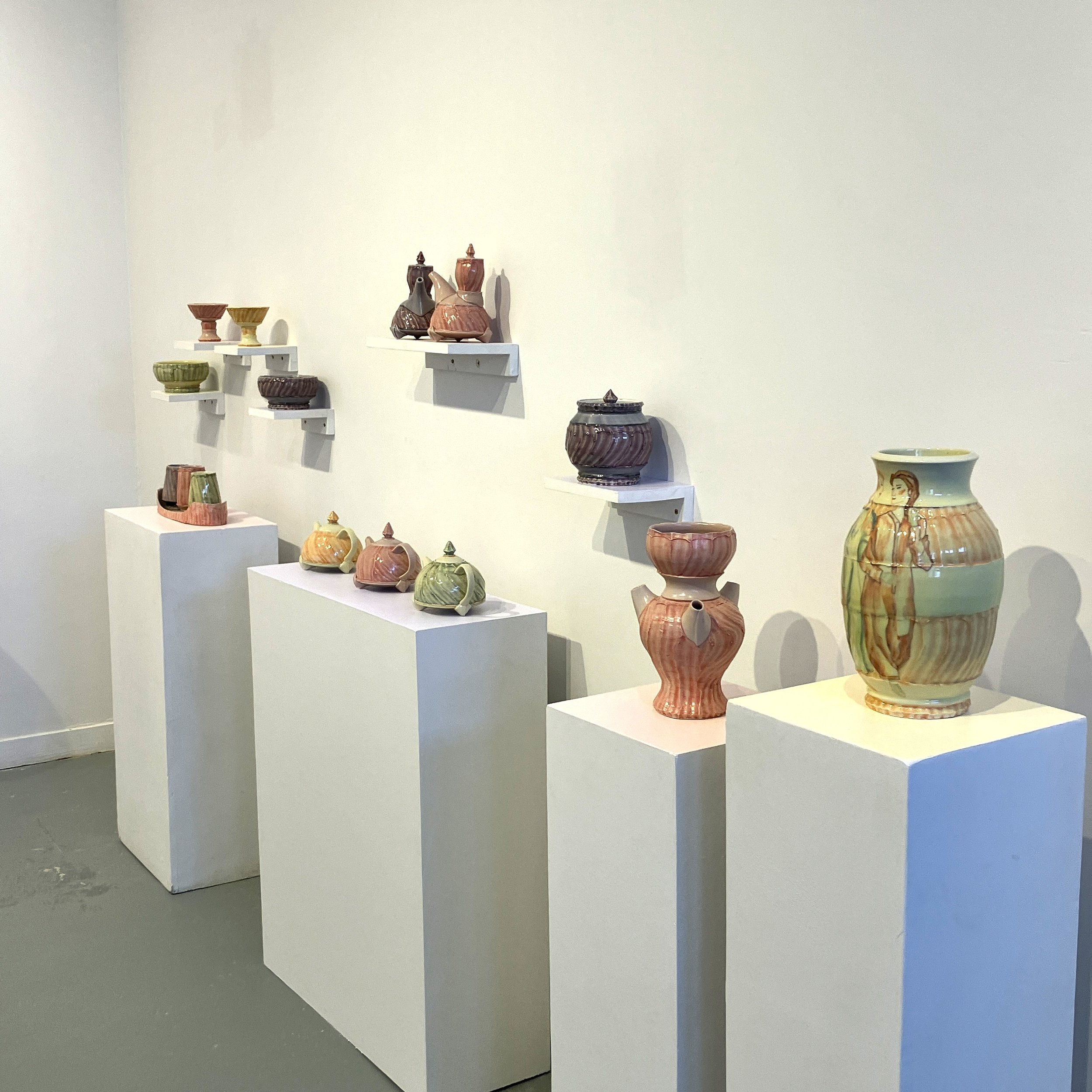Wide angle view of Carley's exhibition The Sunroom, featuring pastel teapots, ewers, vases, and other tableware