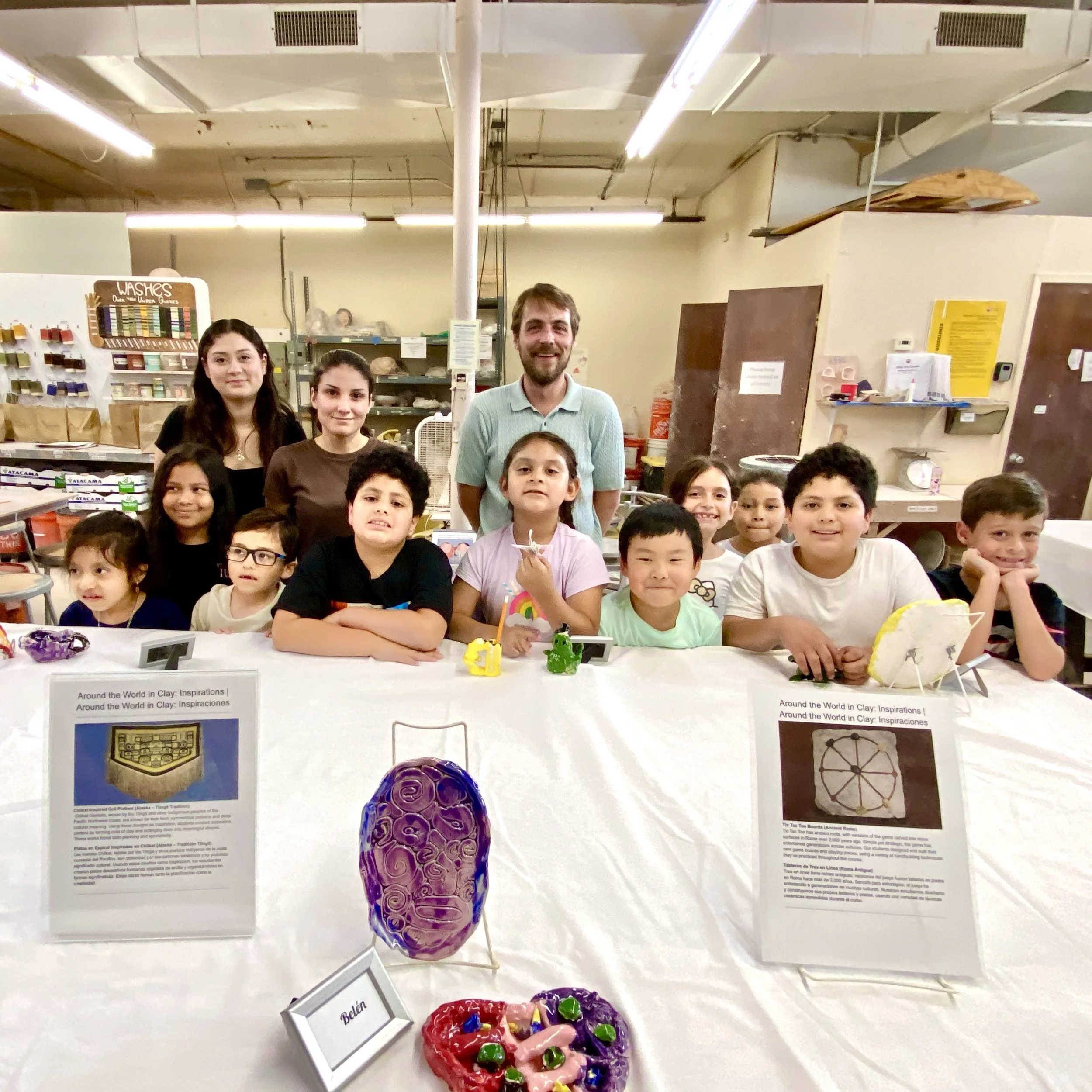 Community Arts Program Manager Brian stands with the kids of Around the World in Clay