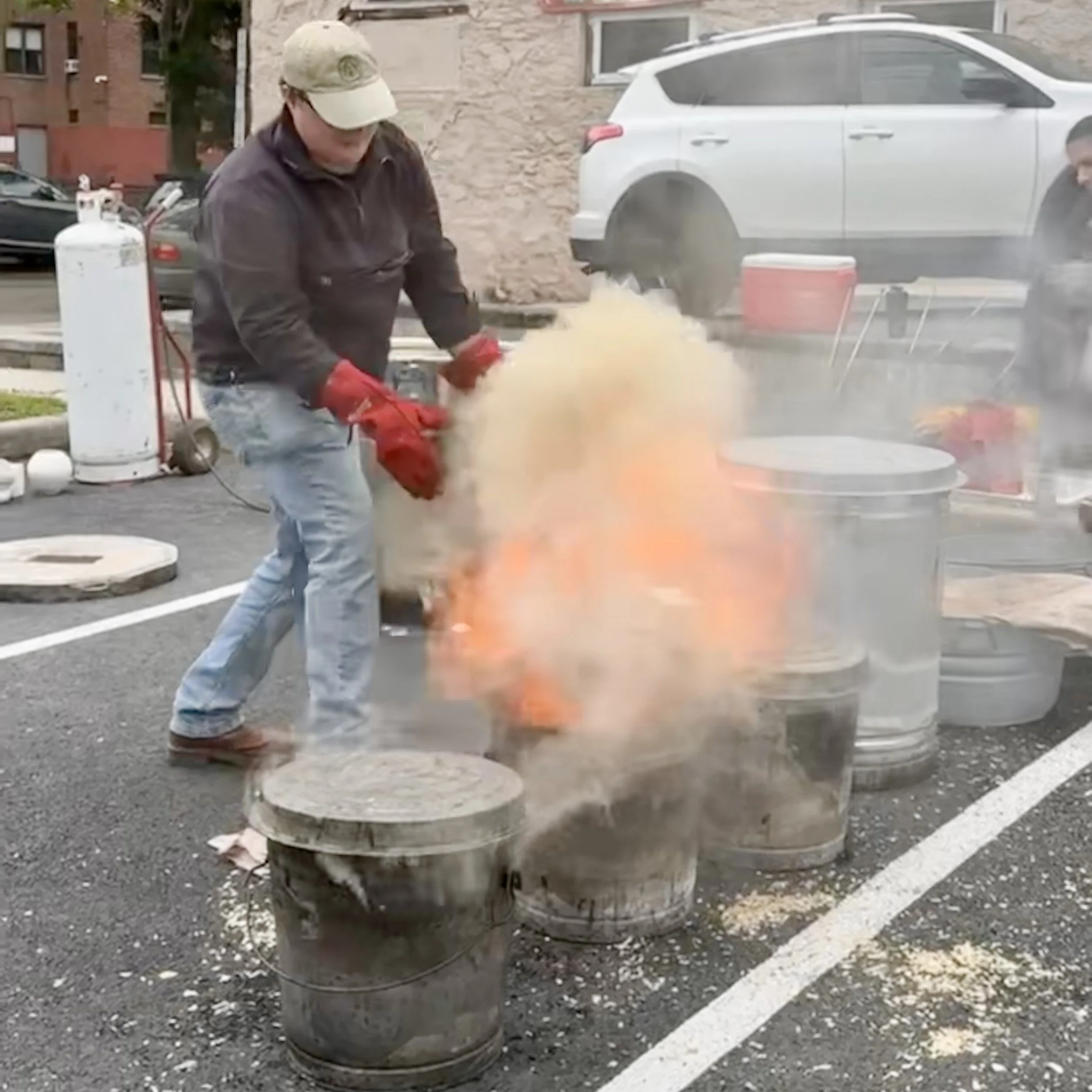 August places a raku pieces in the fire, with smoke and flames spewing out