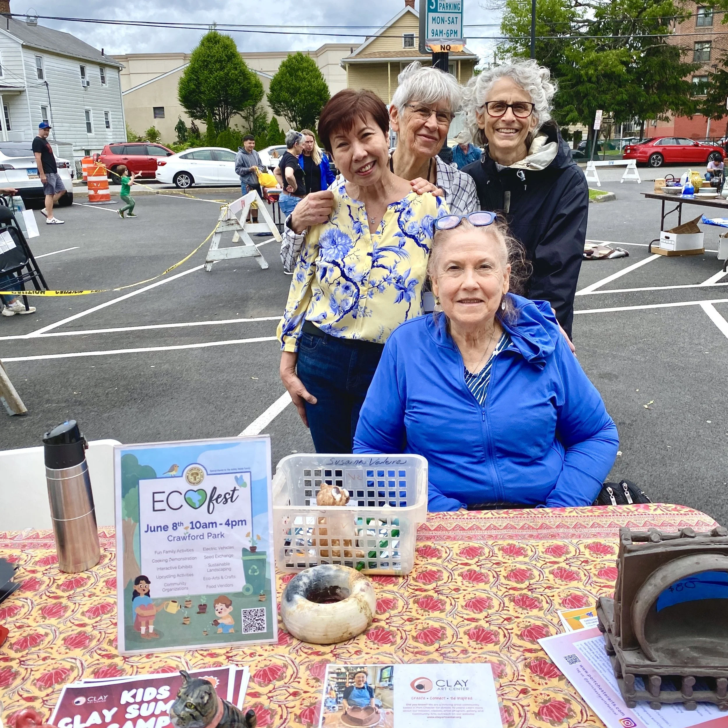Four women smile for a group photo behind the welcome table.