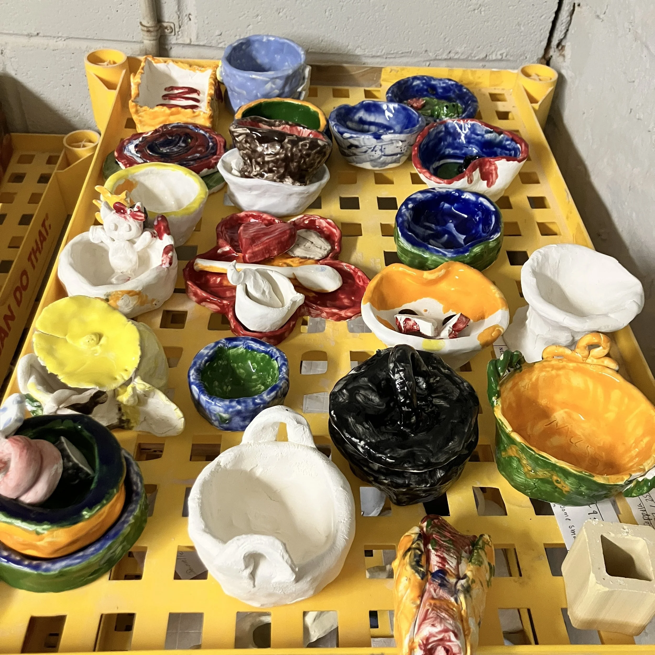 Tray of colorful children's pottery projects.