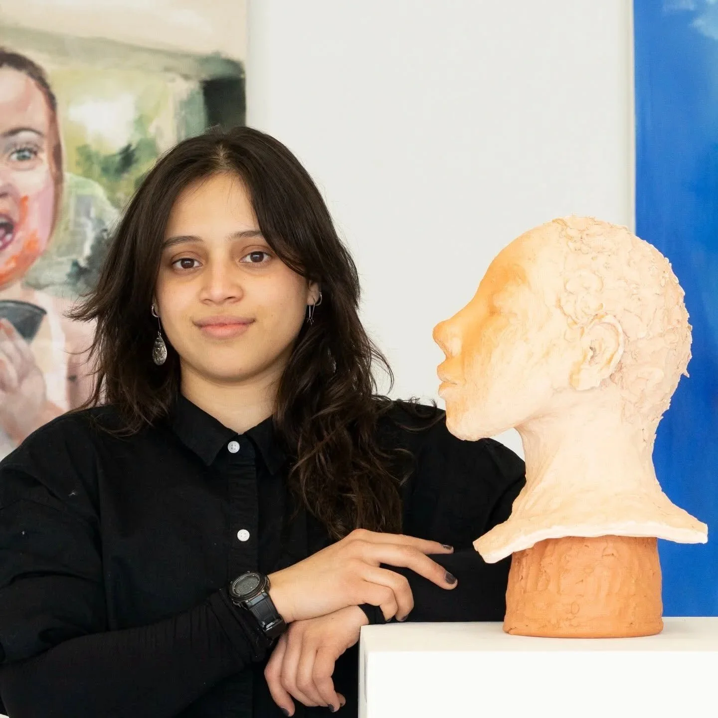 Head shot photo of an artist next to a ceramic sculpture