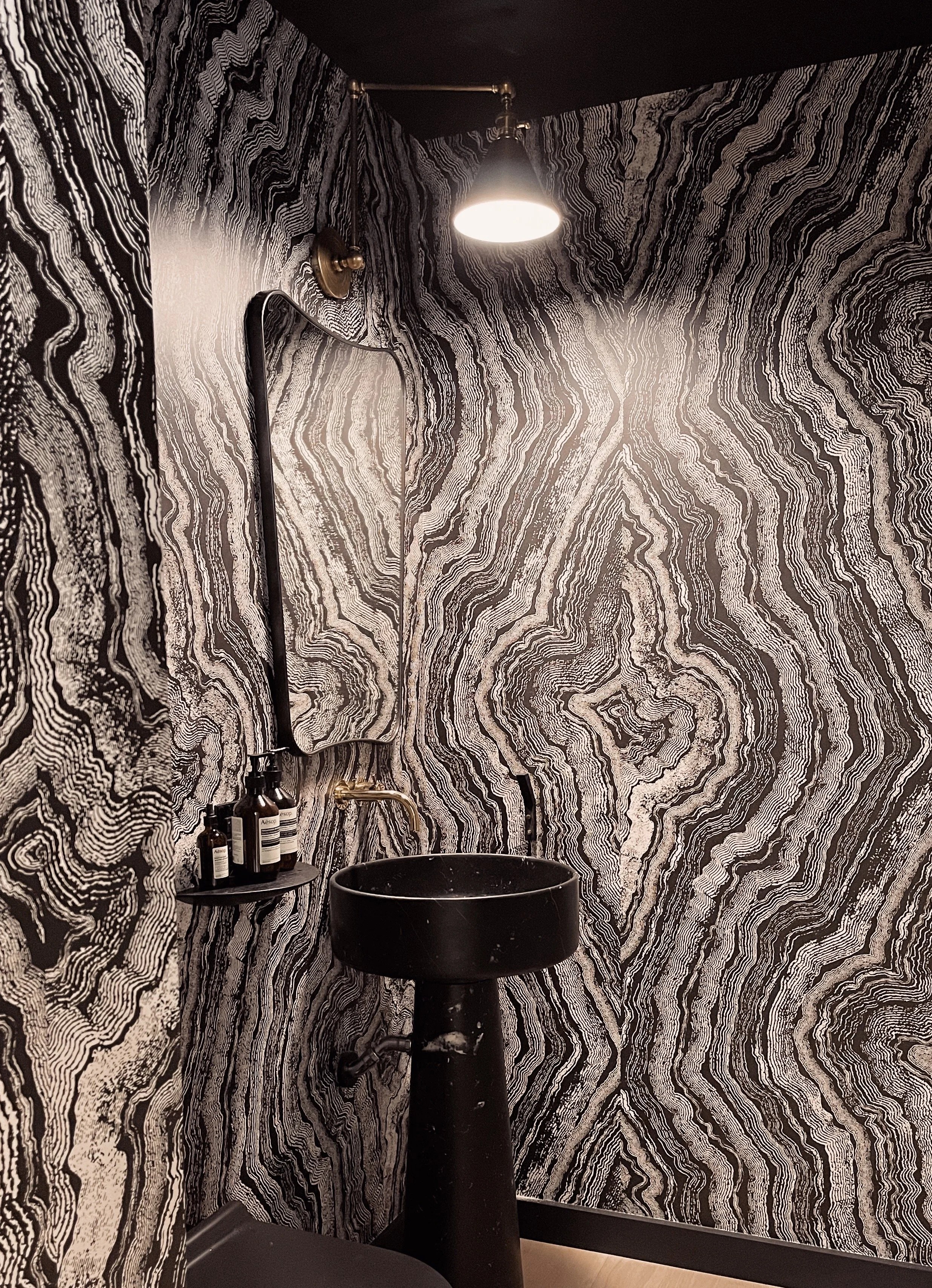 Wallpapered bathroom with marble pedestal sink in New York City