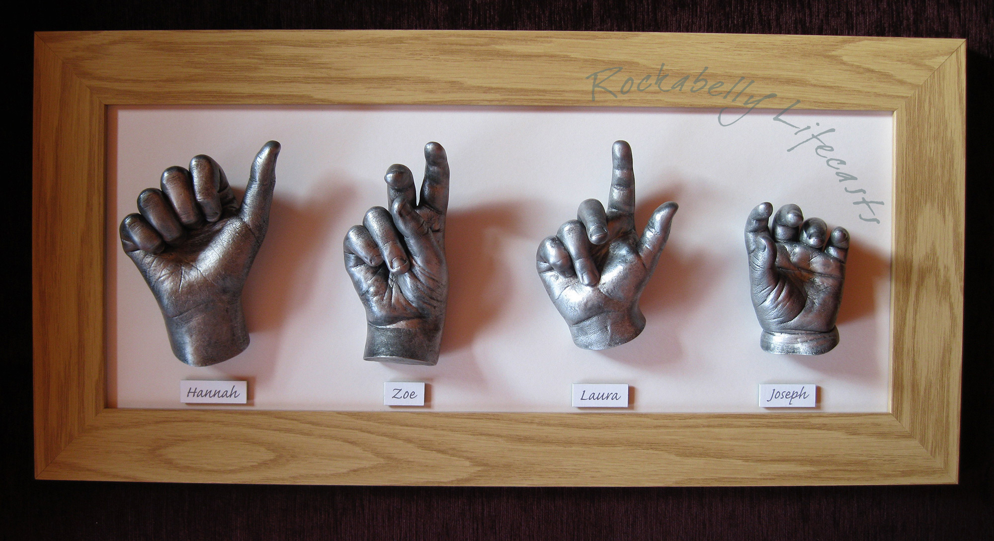 Framed cast hands of four children by Rockabelly Lifecasts