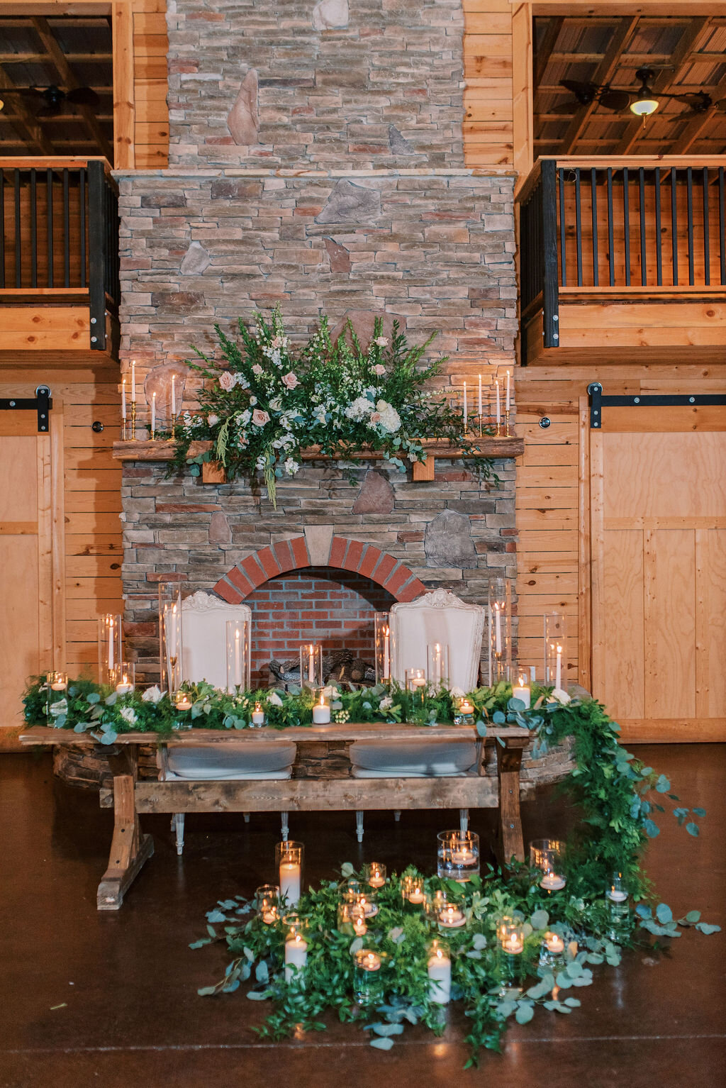 Upgraded mantle and sweetheart table with greenery twh candles garland hurricanes.jpg