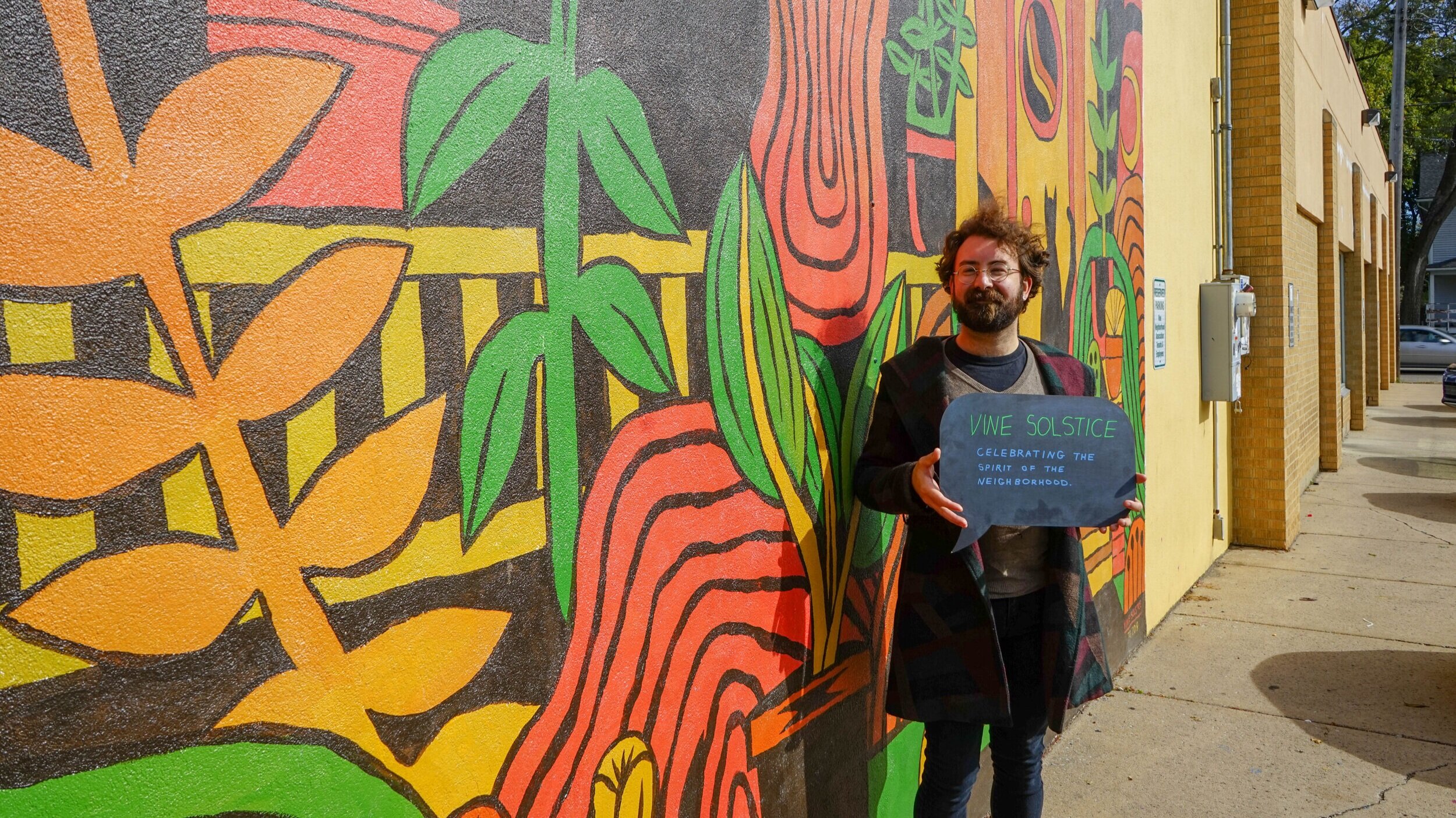  Trevor Grabill in front of his mural on the “Heart of the Vine” building. 