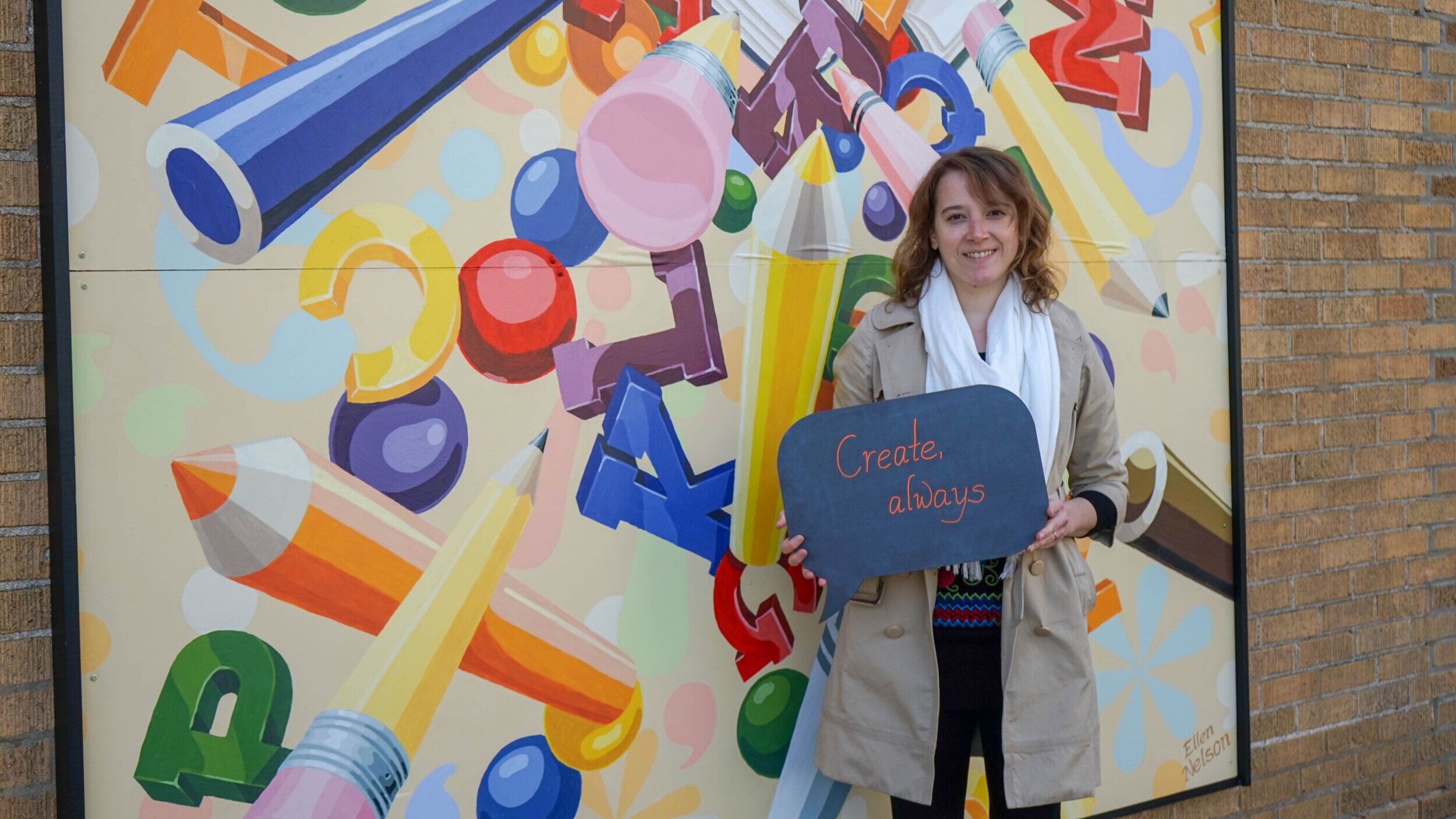  Ellen Nelson in front of her mural on the “Heart of the Vine” building. 