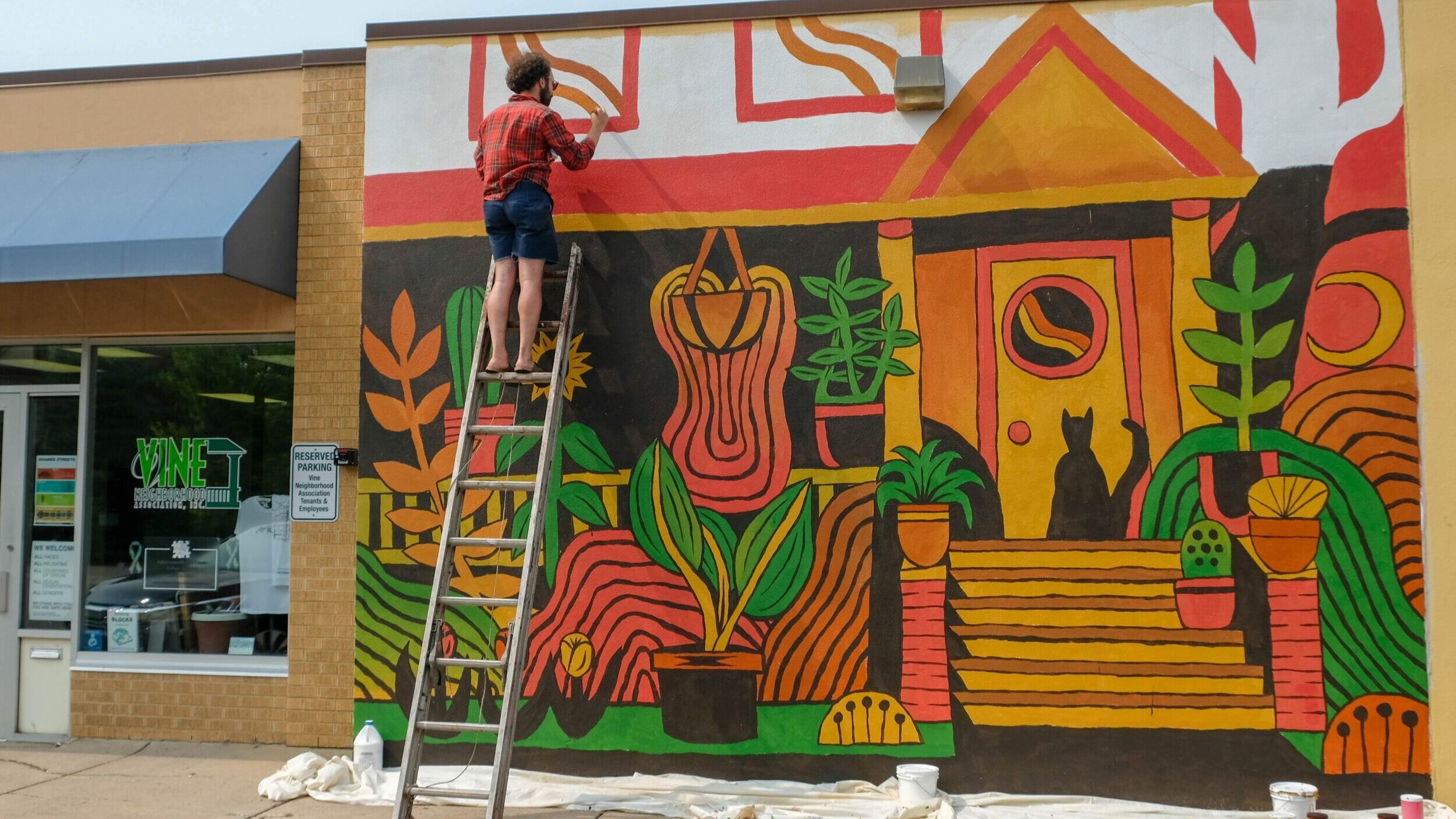  Trevor Grabill painting his mural on the “Heart of the Vine” building. 
